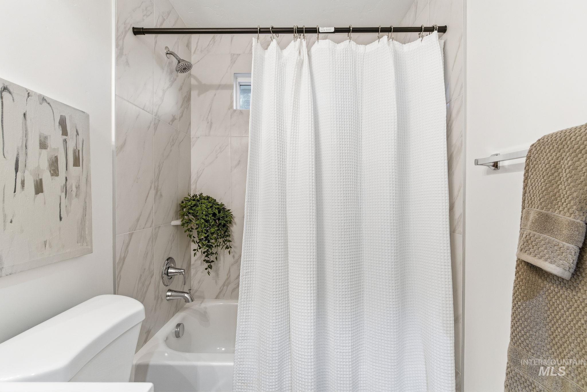 Full bath with shower / bathtub combination with curtain and toilet
