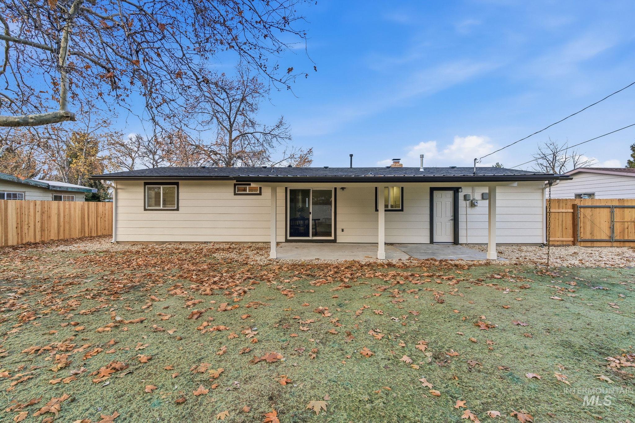 Back of house featuring a fenced backyard, a patio area, and a chimney