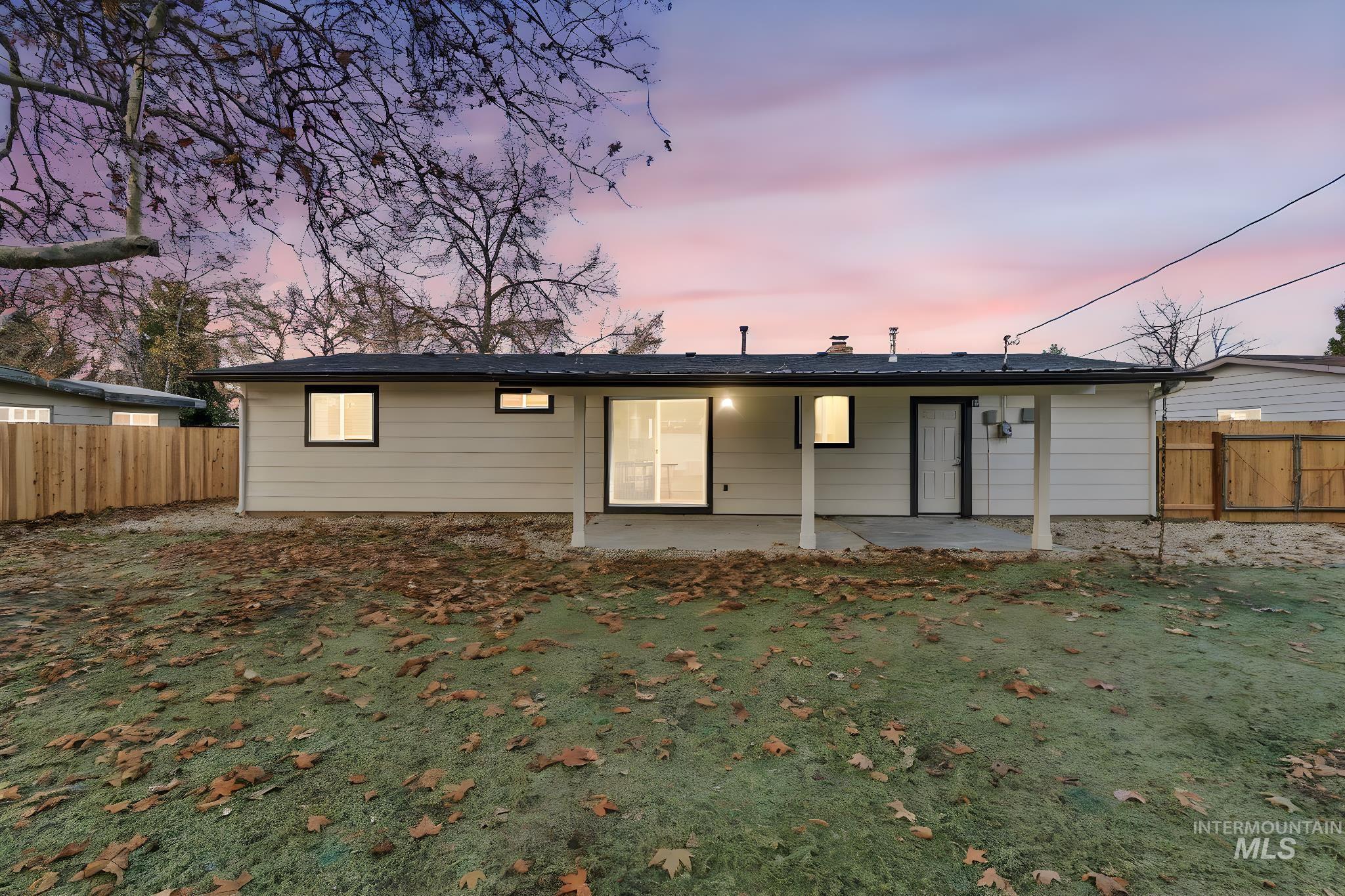 Back of house at dusk featuring a patio