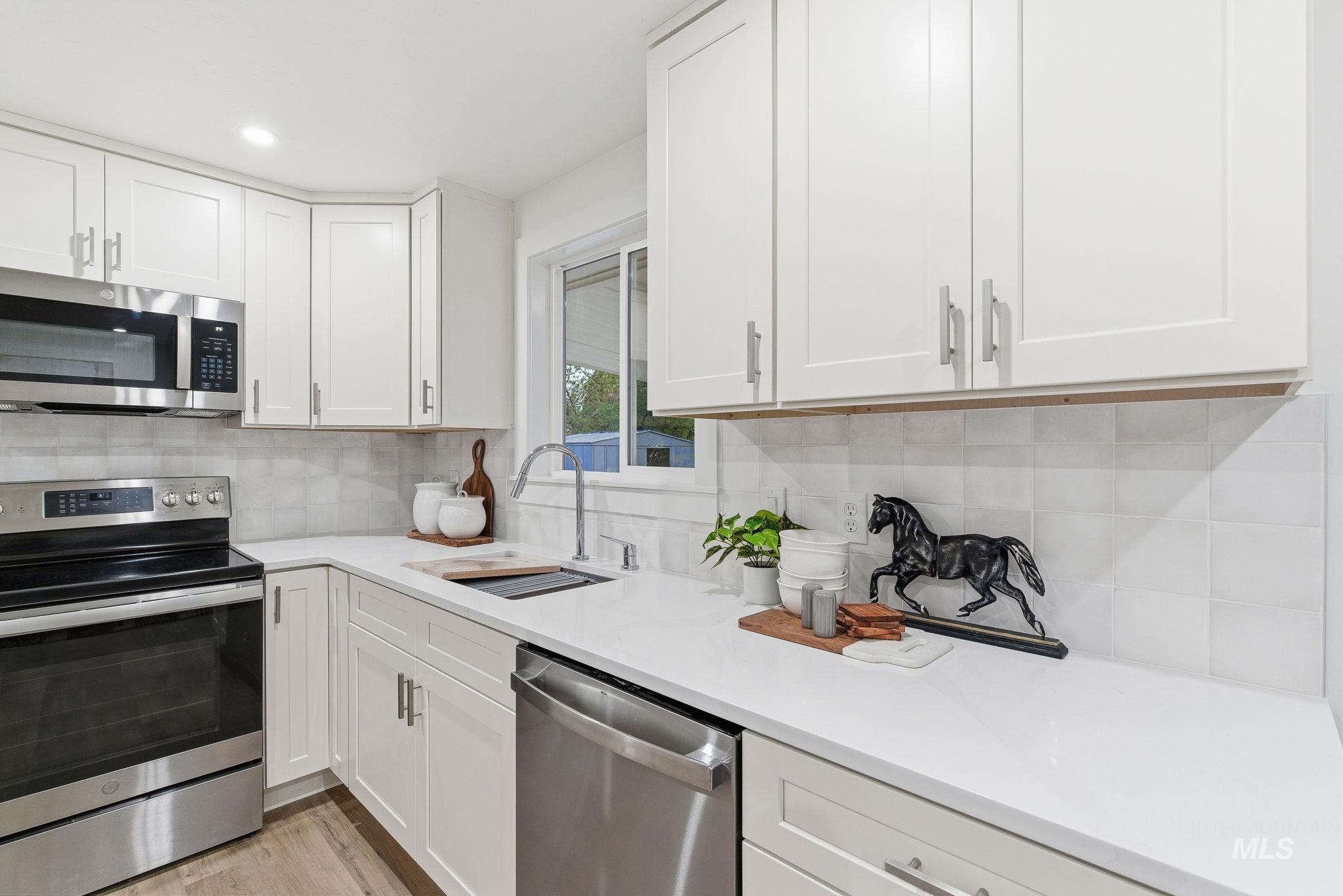 Kitchen featuring stainless steel appliances, white cabinets, and recessed lighting