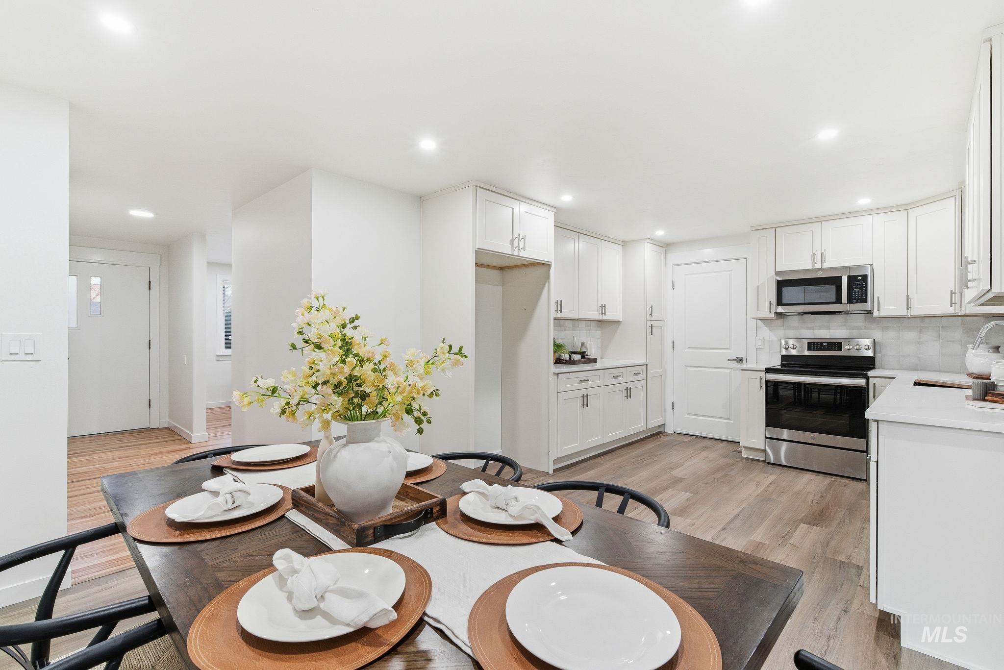 Dining area with light wood-style flooring and recessed lighting