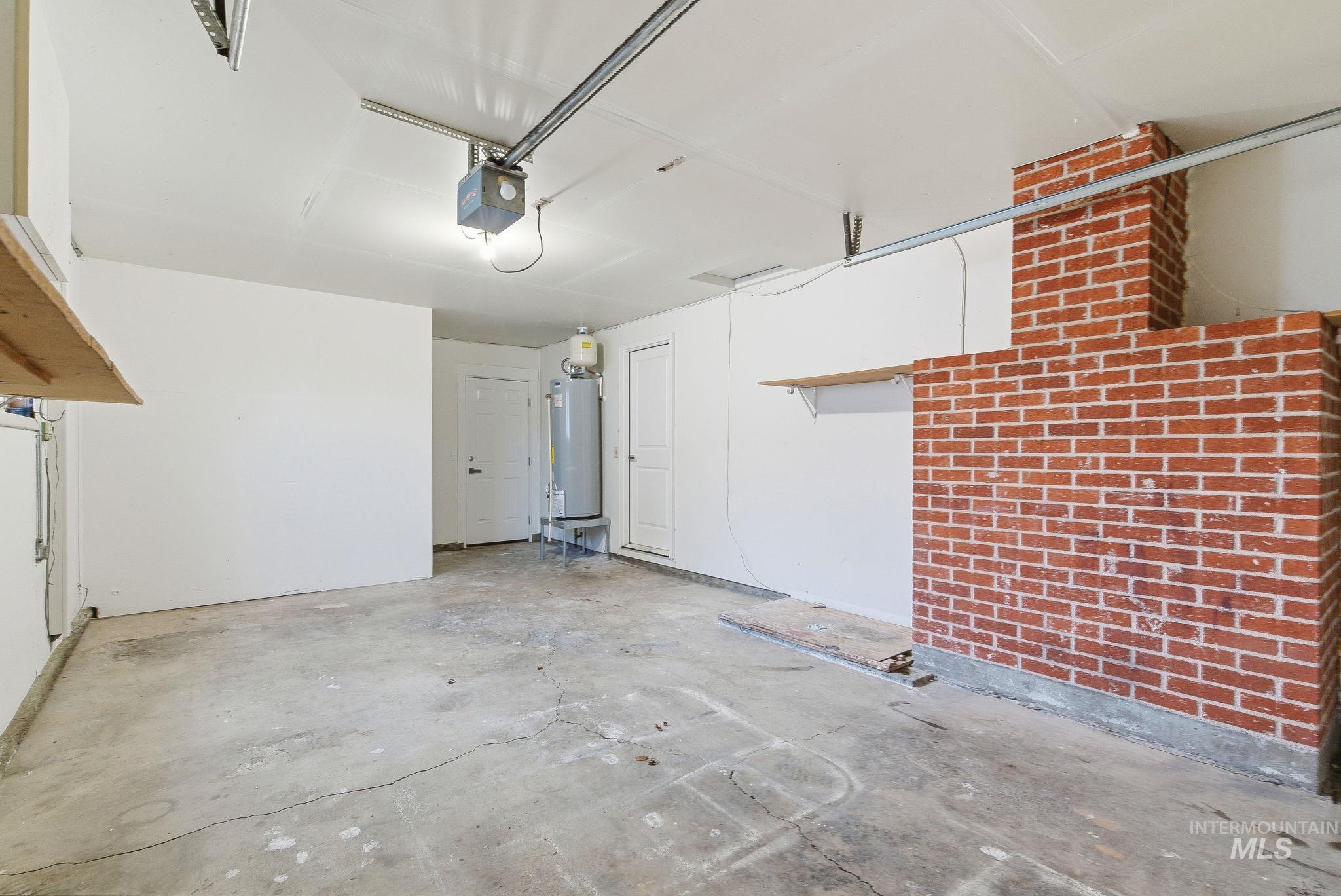 Garage featuring water heater and a garage door opener