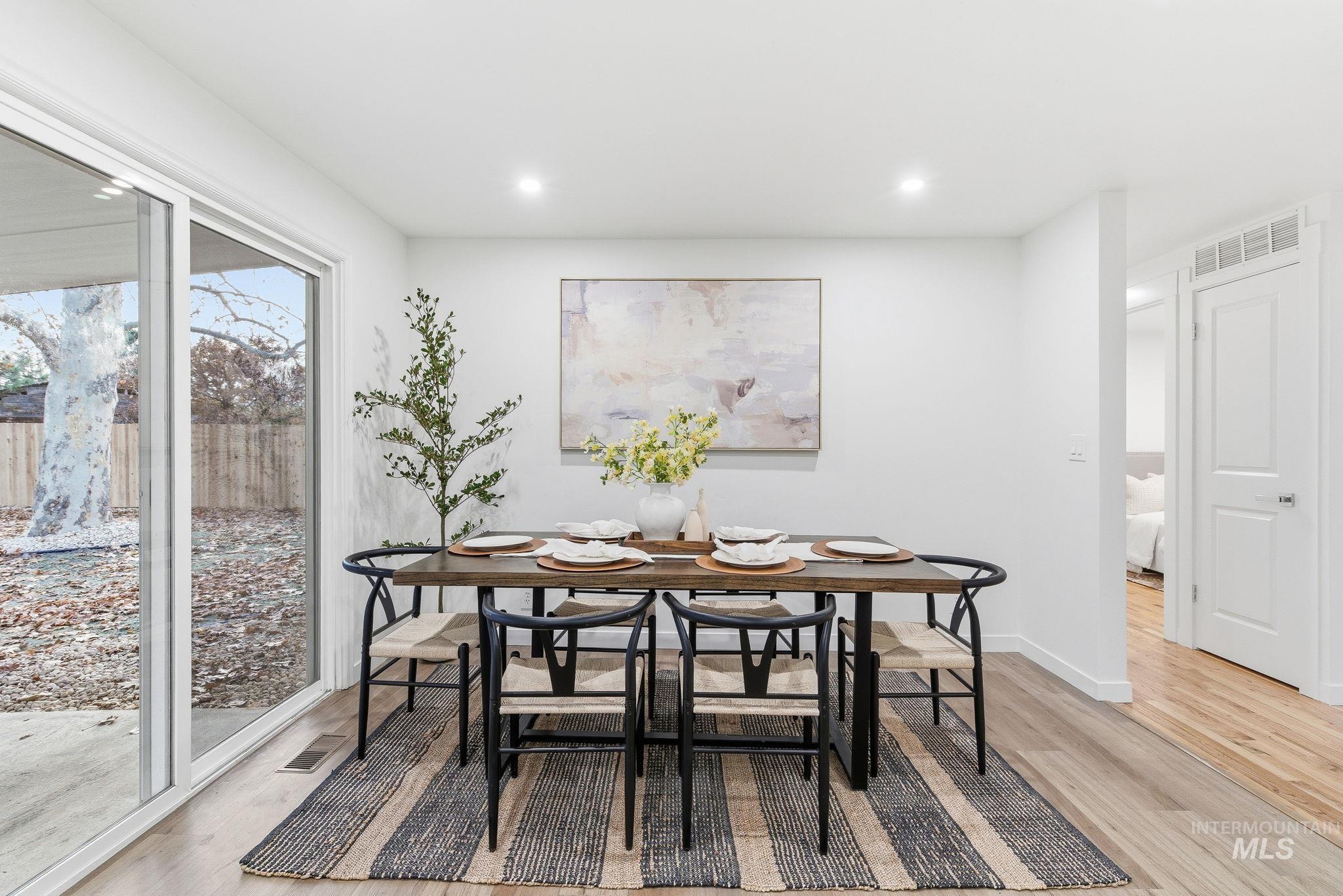Dining area with light wood-style floors and recessed lighting