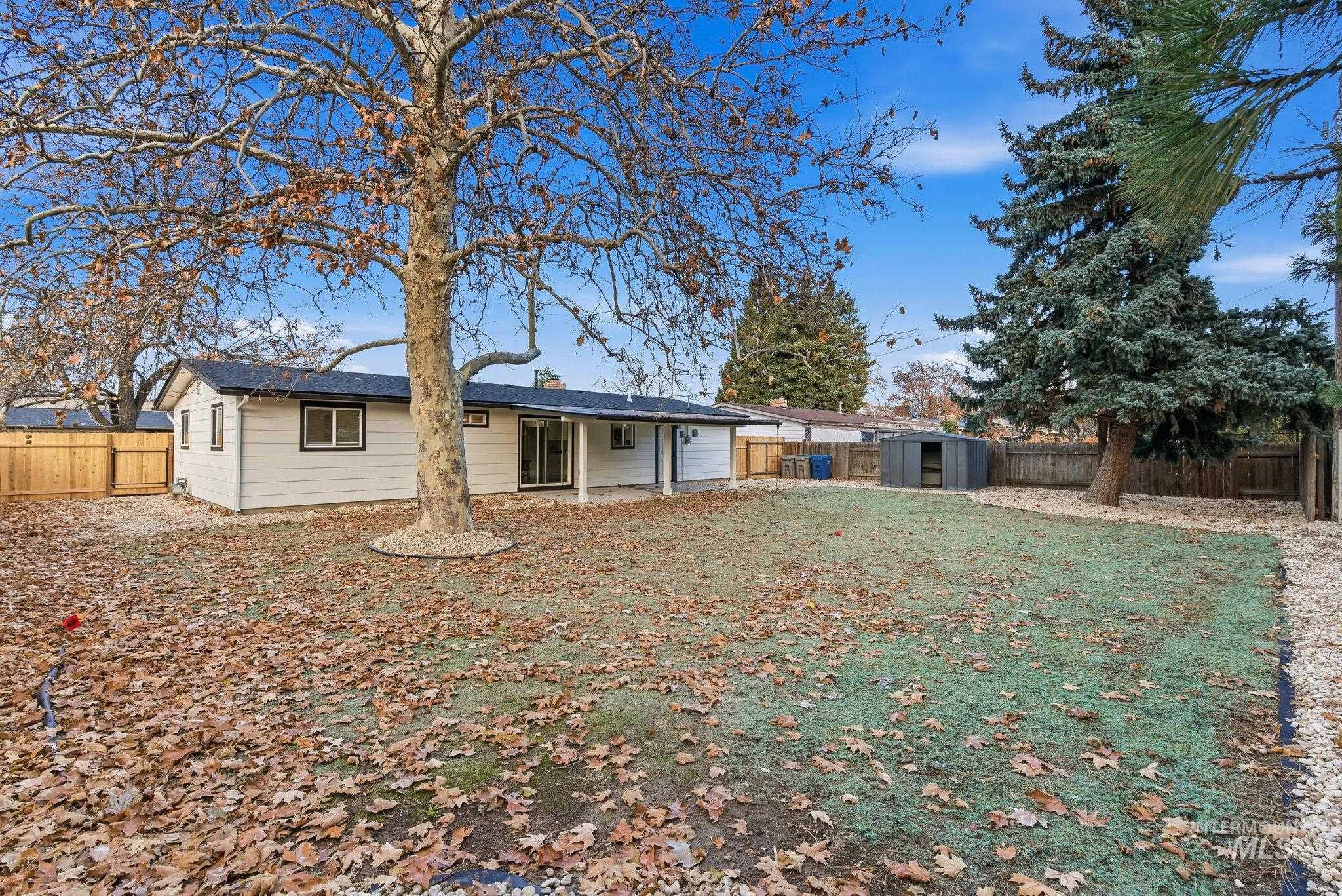 Rear view of property featuring a fenced backyard, a storage shed, a chimney, and a patio