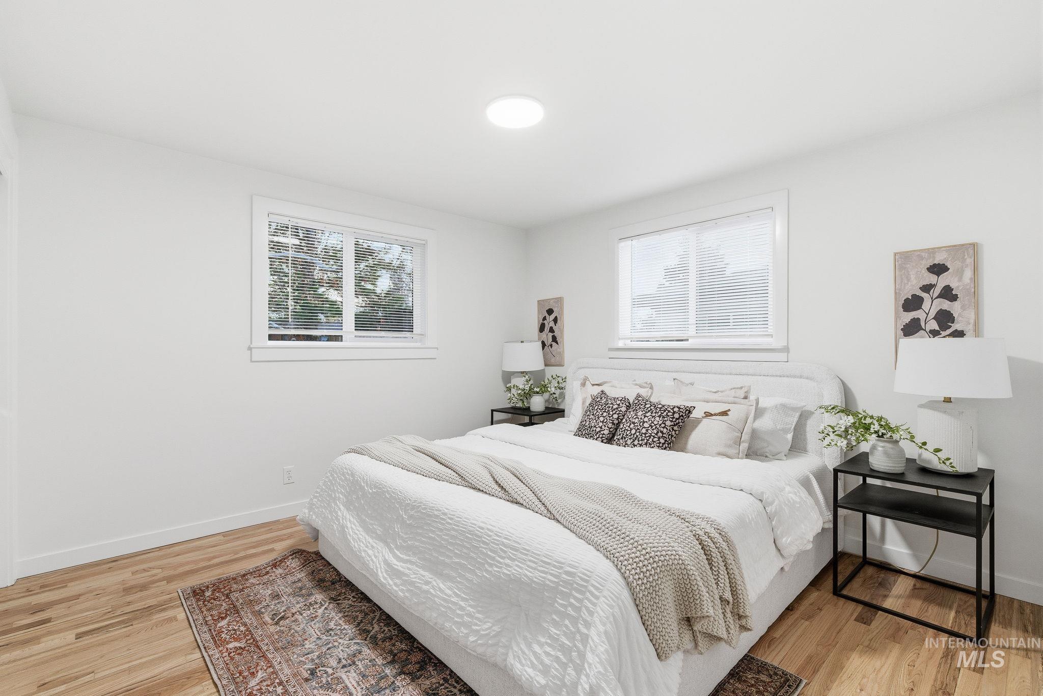 Bedroom featuring multiple windows and light wood-style floors