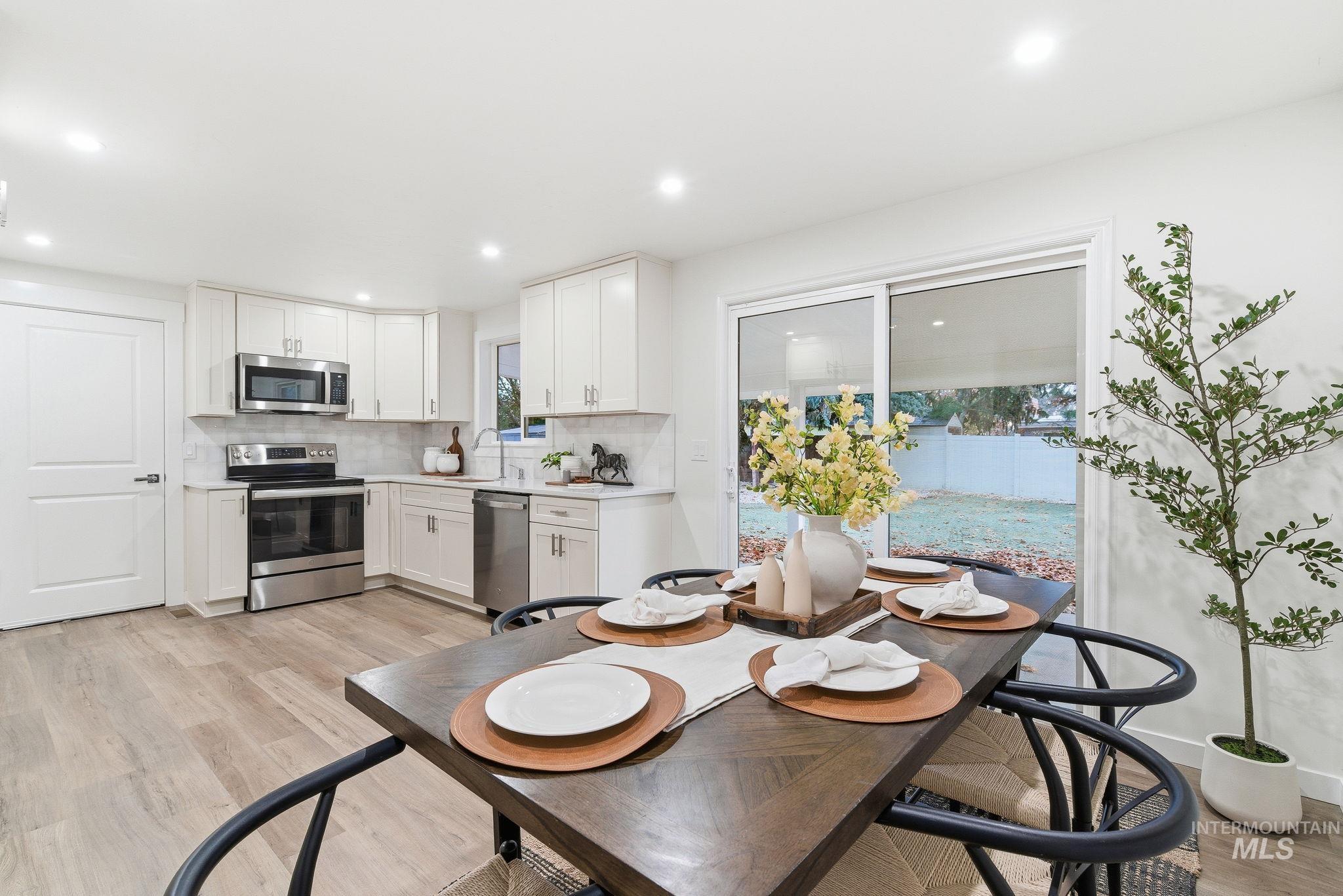 Dining area with light wood-style flooring and recessed lighting