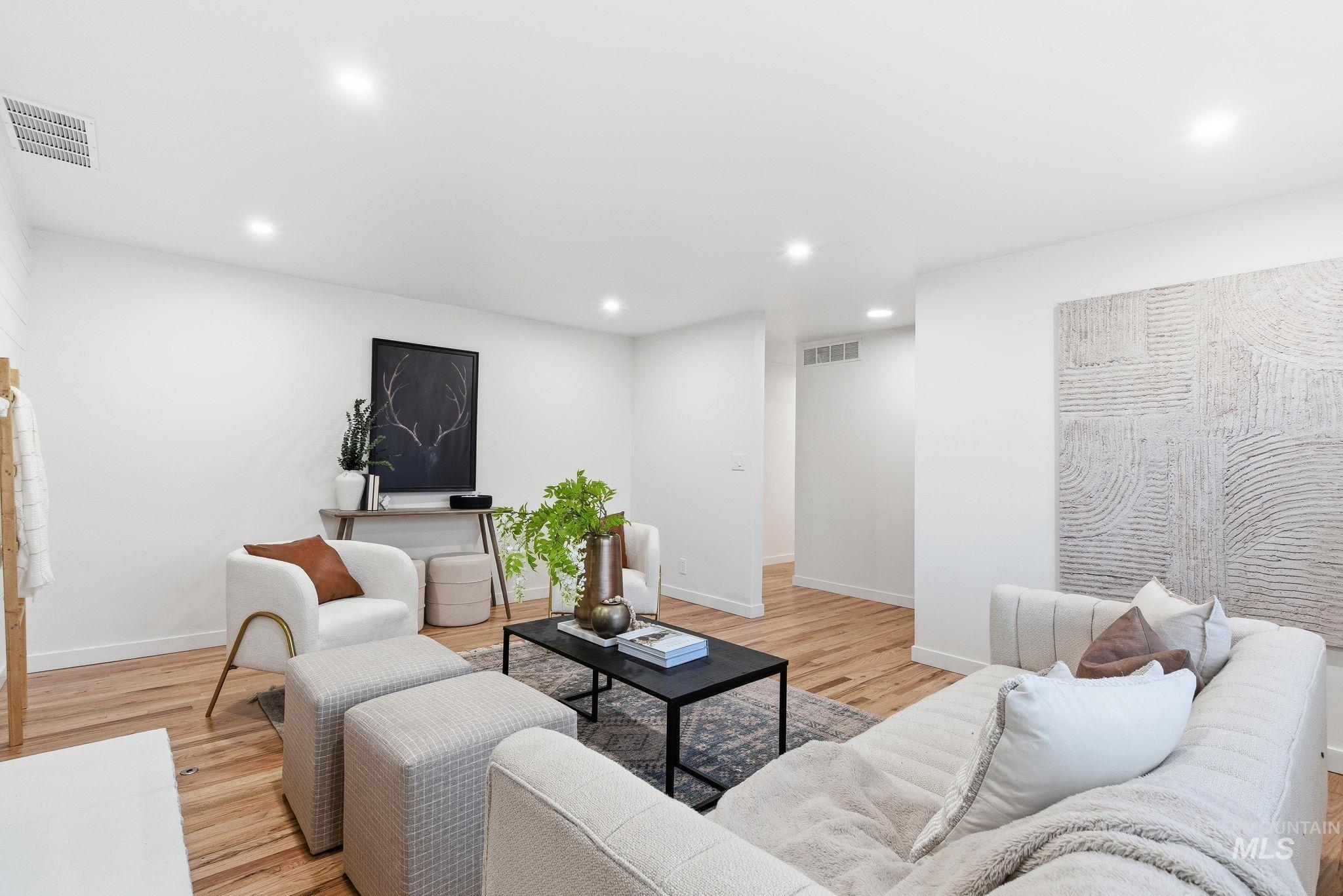 Living area with recessed lighting and light wood-style flooring