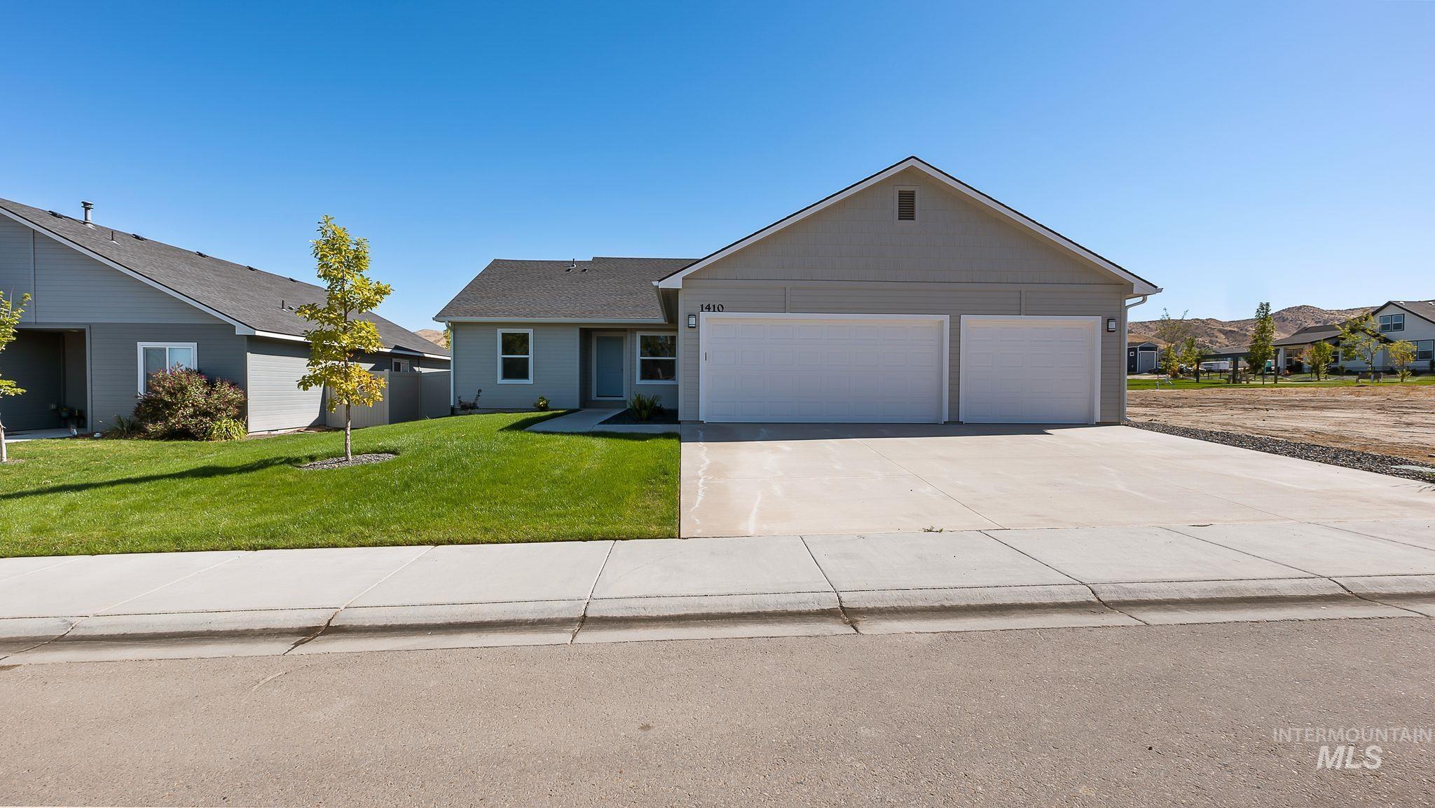 Single story home featuring driveway, a front lawn, and an attached garage