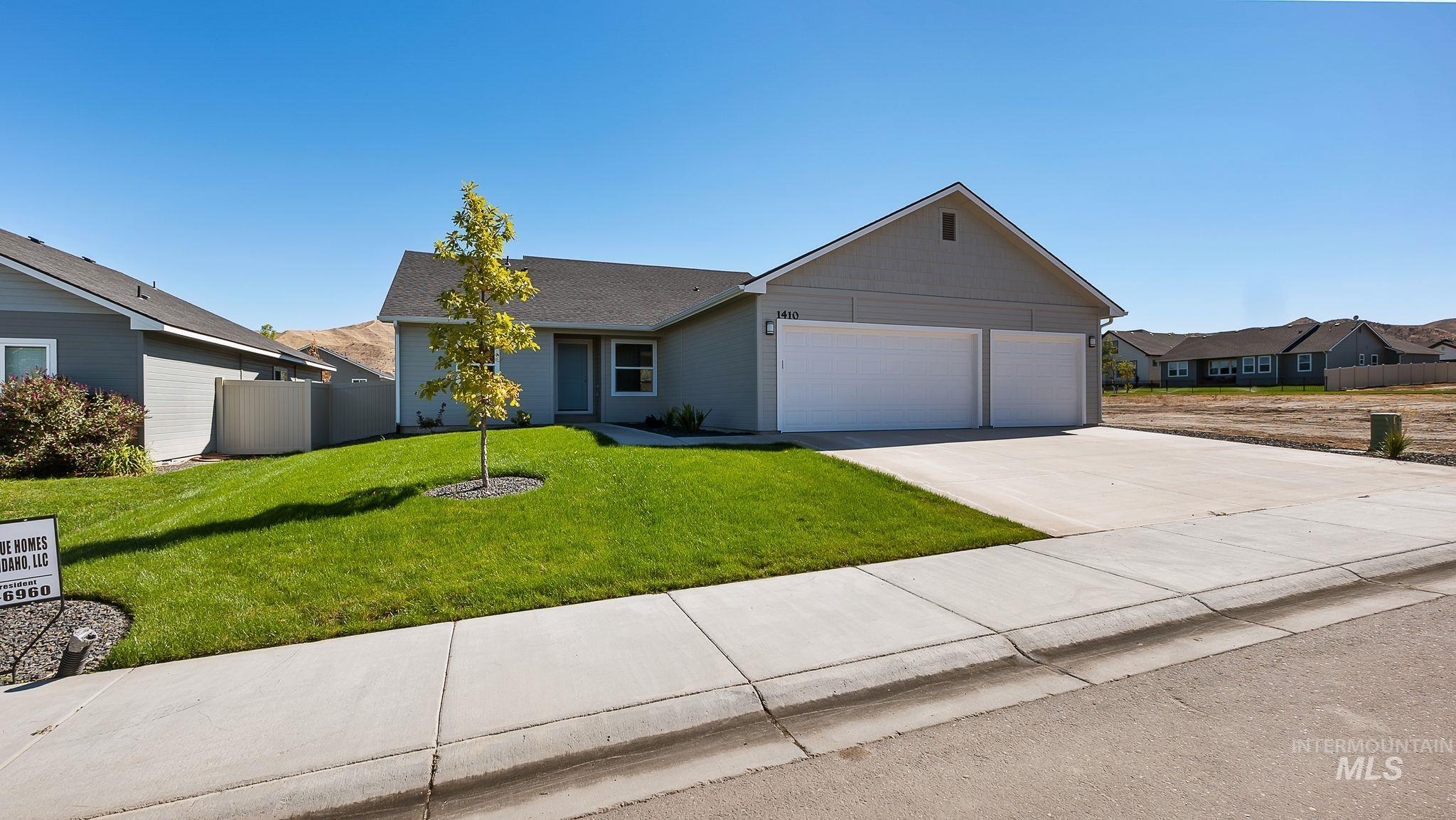 Single story home featuring concrete driveway and a garage