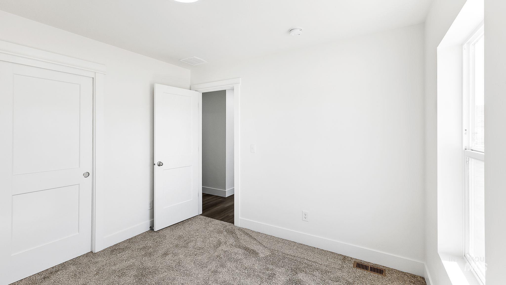 Unfurnished bedroom featuring carpet and baseboards