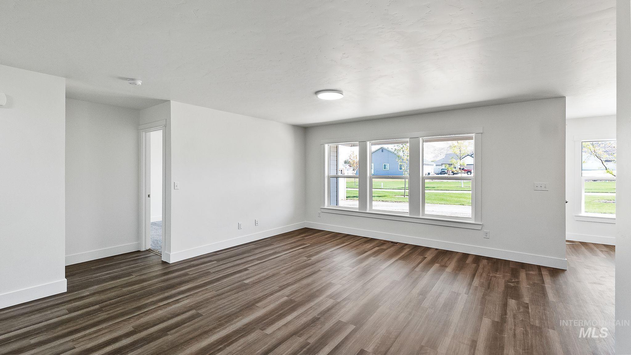 Unfurnished living room featuring healthy amount of natural light and dark wood finished floors