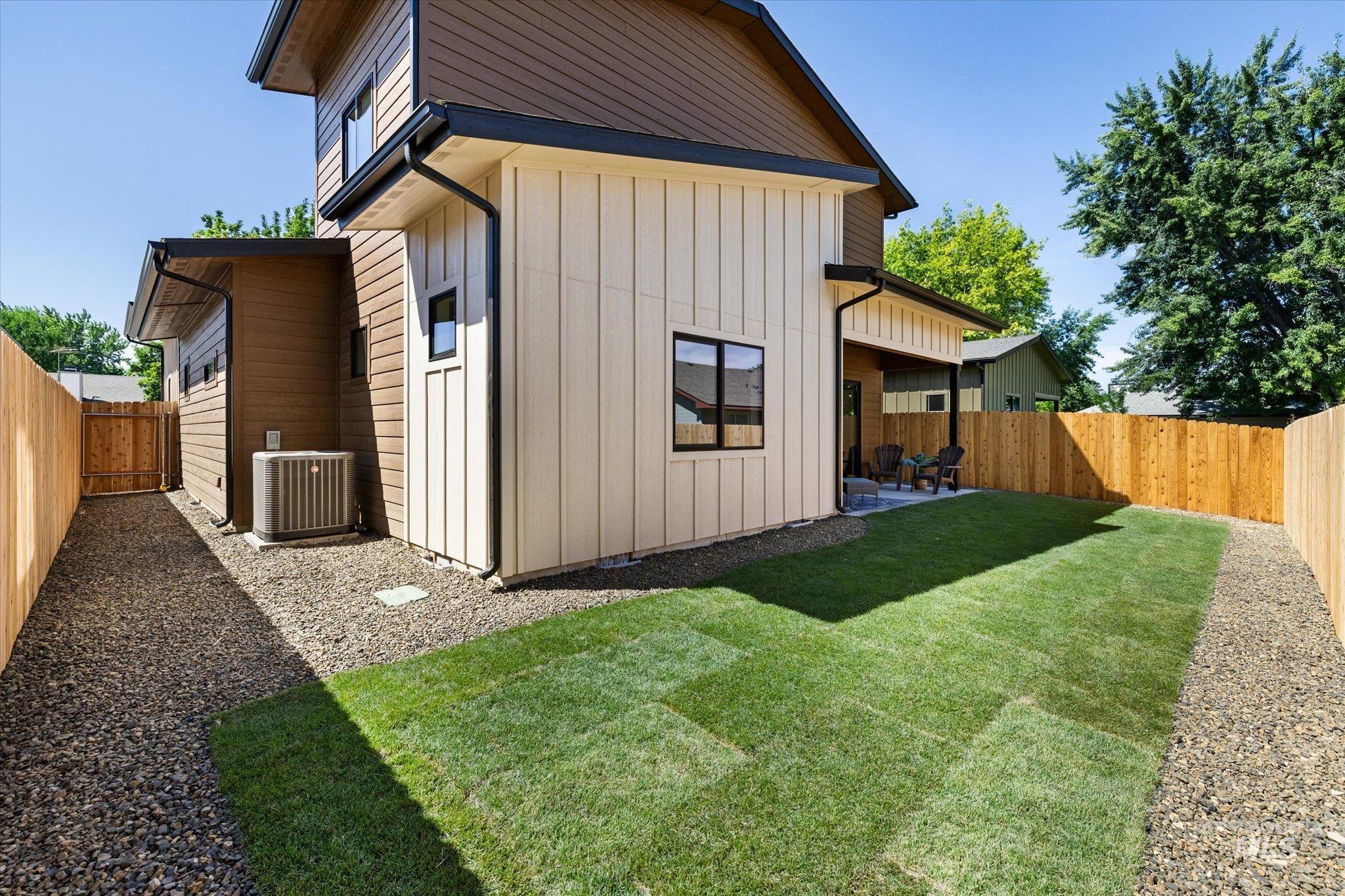 Rear view of house with a fenced backyard and a patio area