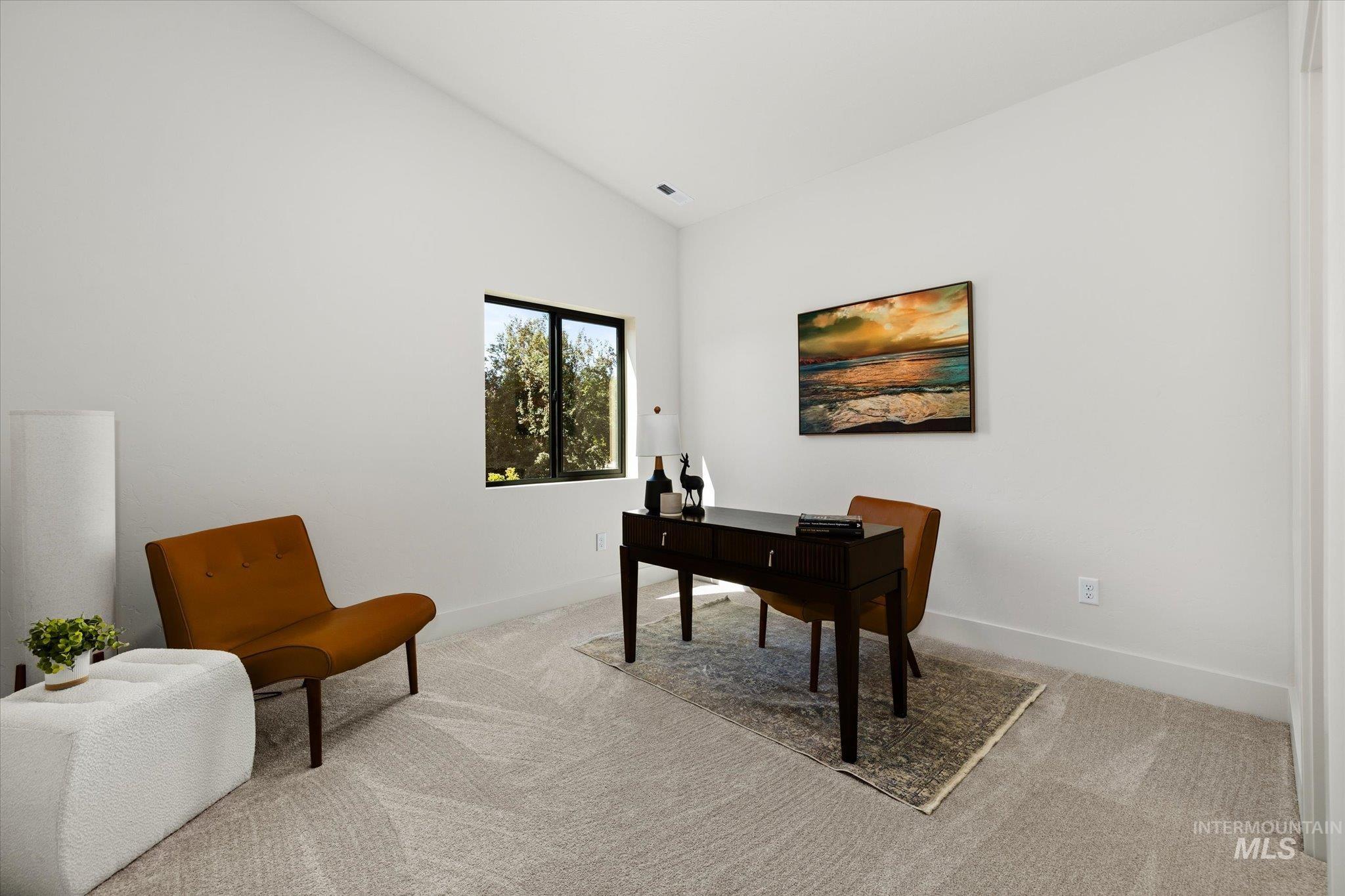 Office space with vaulted ceiling and carpet flooring