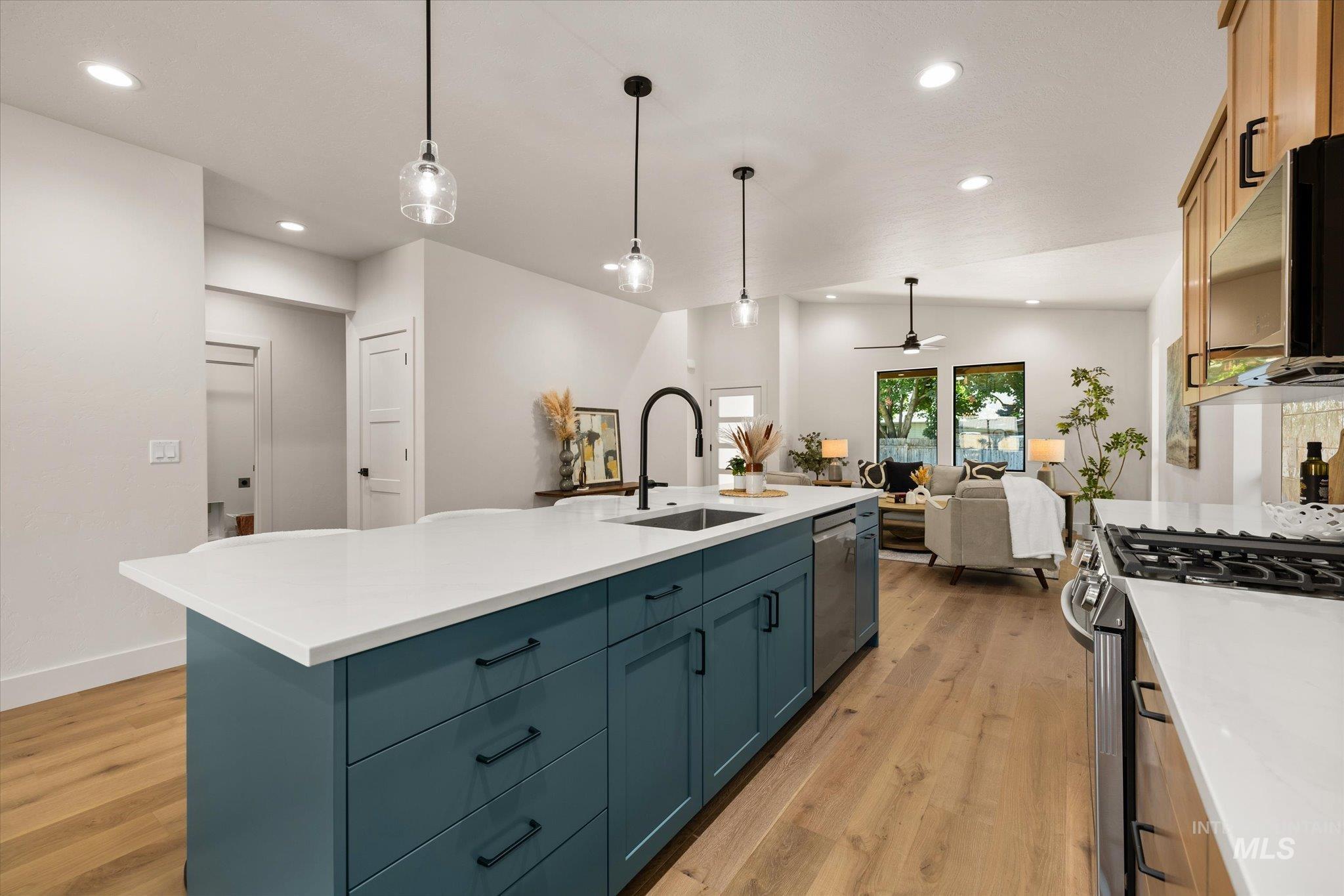 Kitchen featuring recessed lighting, light wood finished floors, appliances with stainless steel finishes, open floor plan, and light countertops