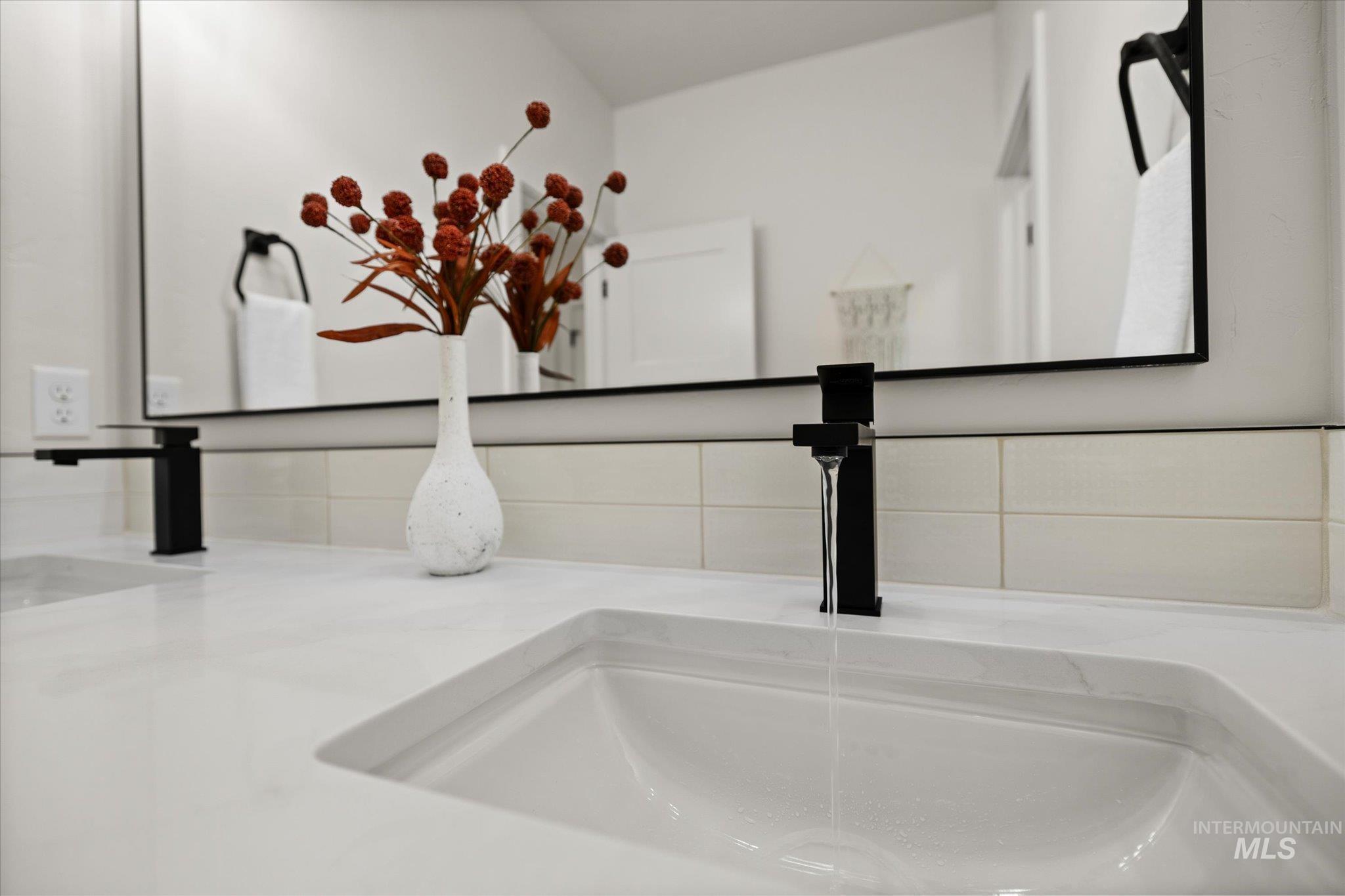 Bathroom view of decorative backsplash and double vanity