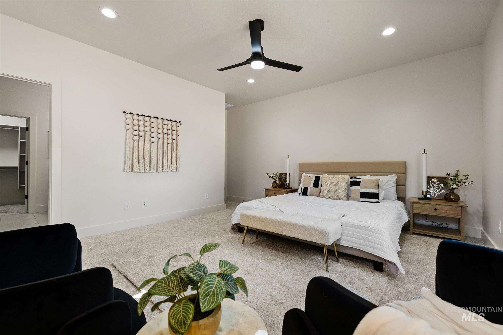 Bedroom with light colored carpet, recessed lighting, ceiling fan, and a spacious closet
