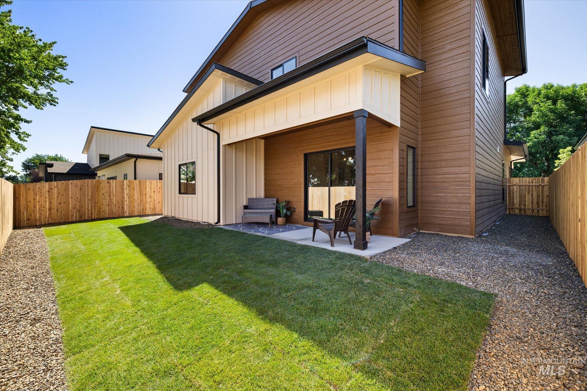 Rear view of property with a fenced backyard, a patio, and board and batten siding