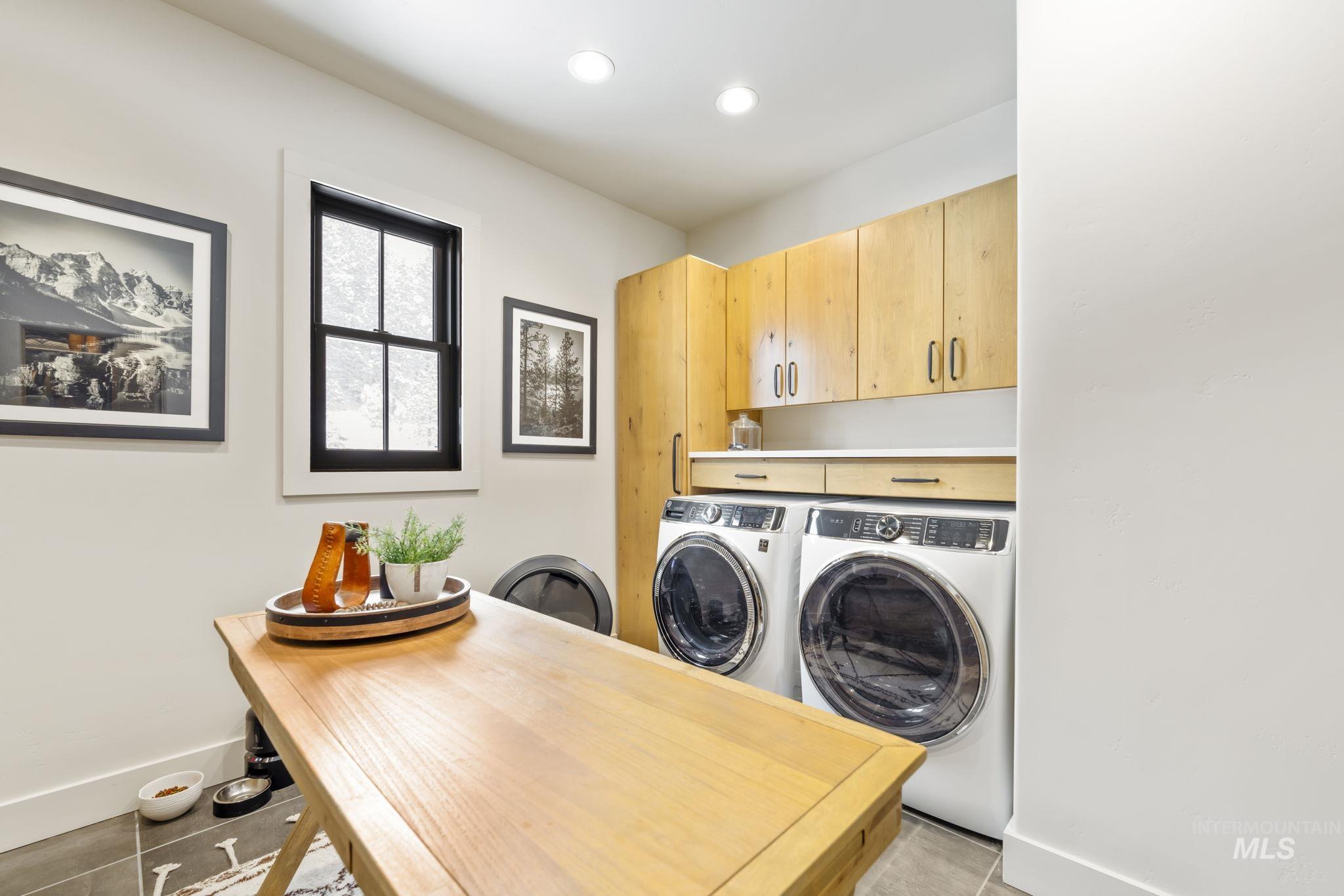 Laundry area featuring washer and clothes dryer, cabinet space, light tile patterned flooring, and recessed lighting - Main Floor