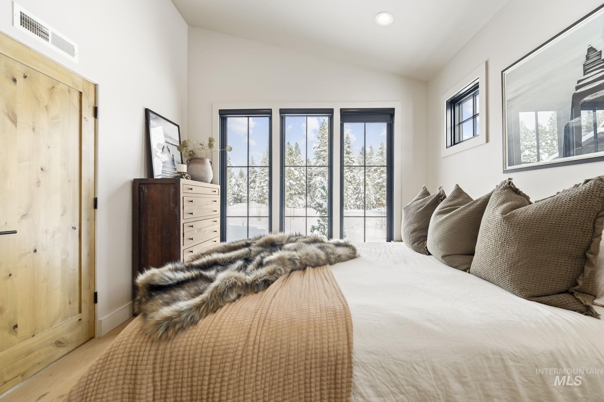 Jr Suite Bedroom featuring vaulted ceiling, access to outside, and wood finished floors