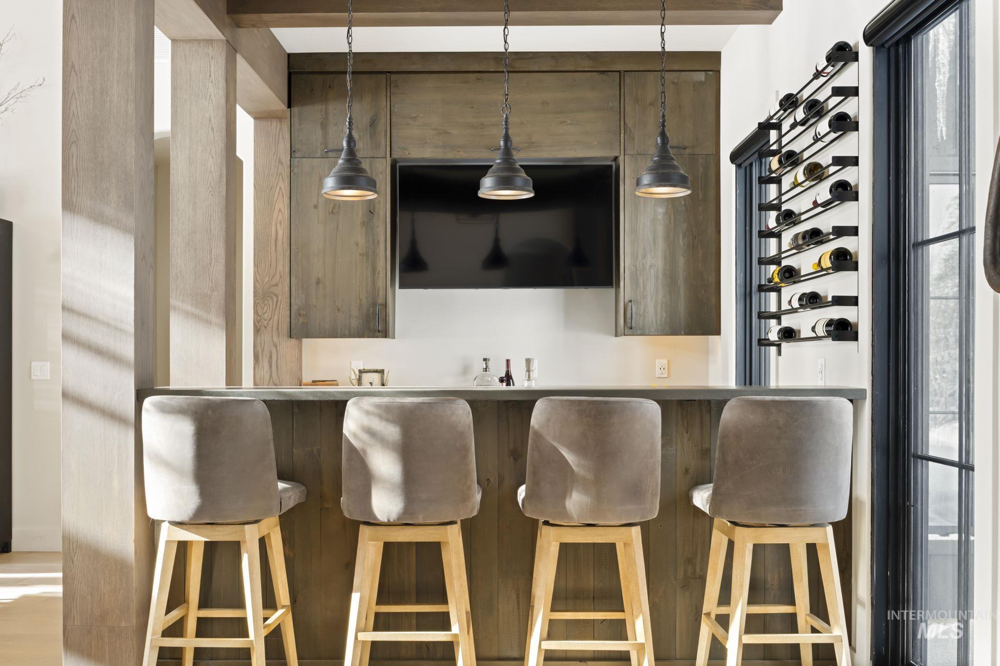 Bar area featuring decorative light fixtures and light countertops