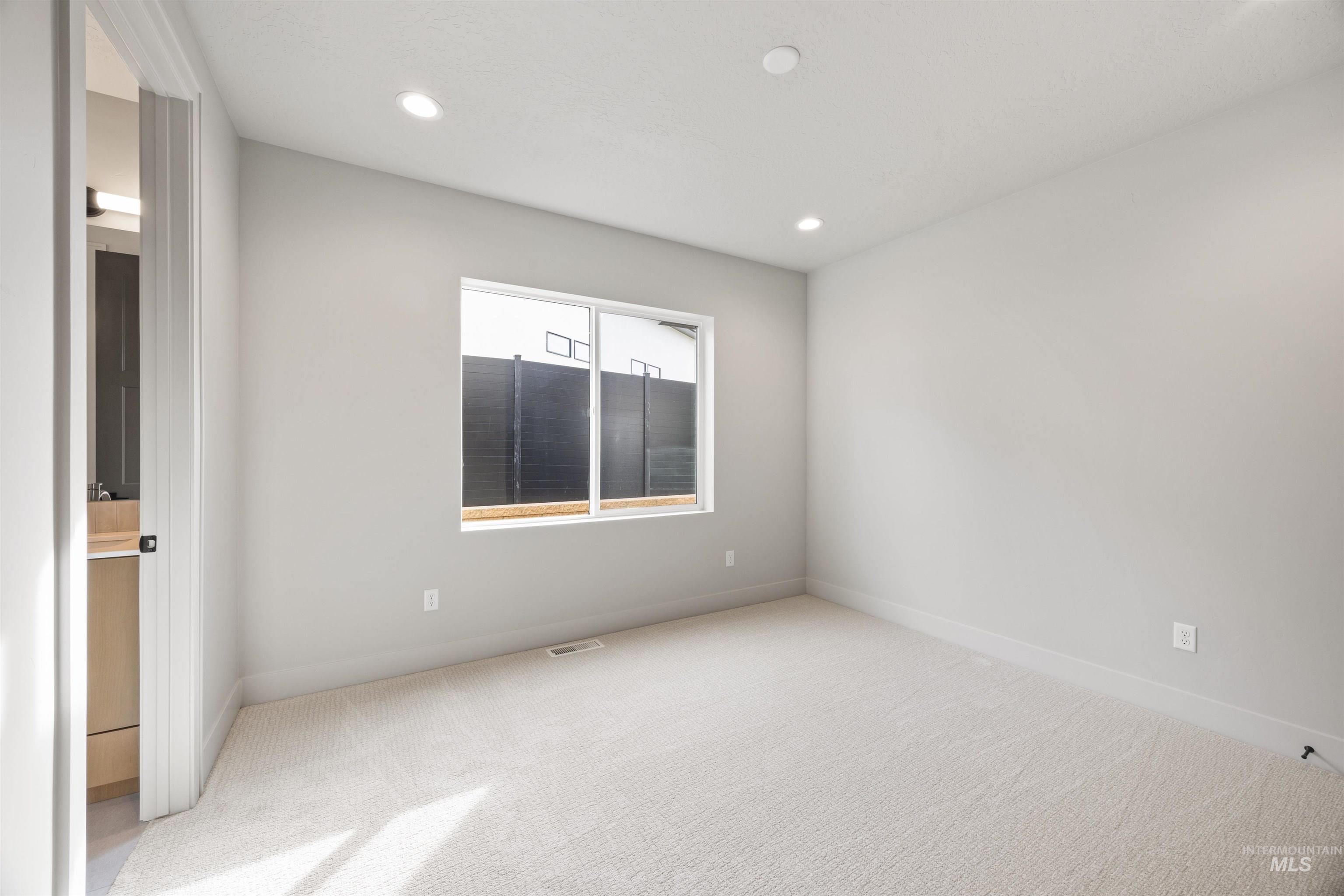 Spare room with light carpet and recessed lighting