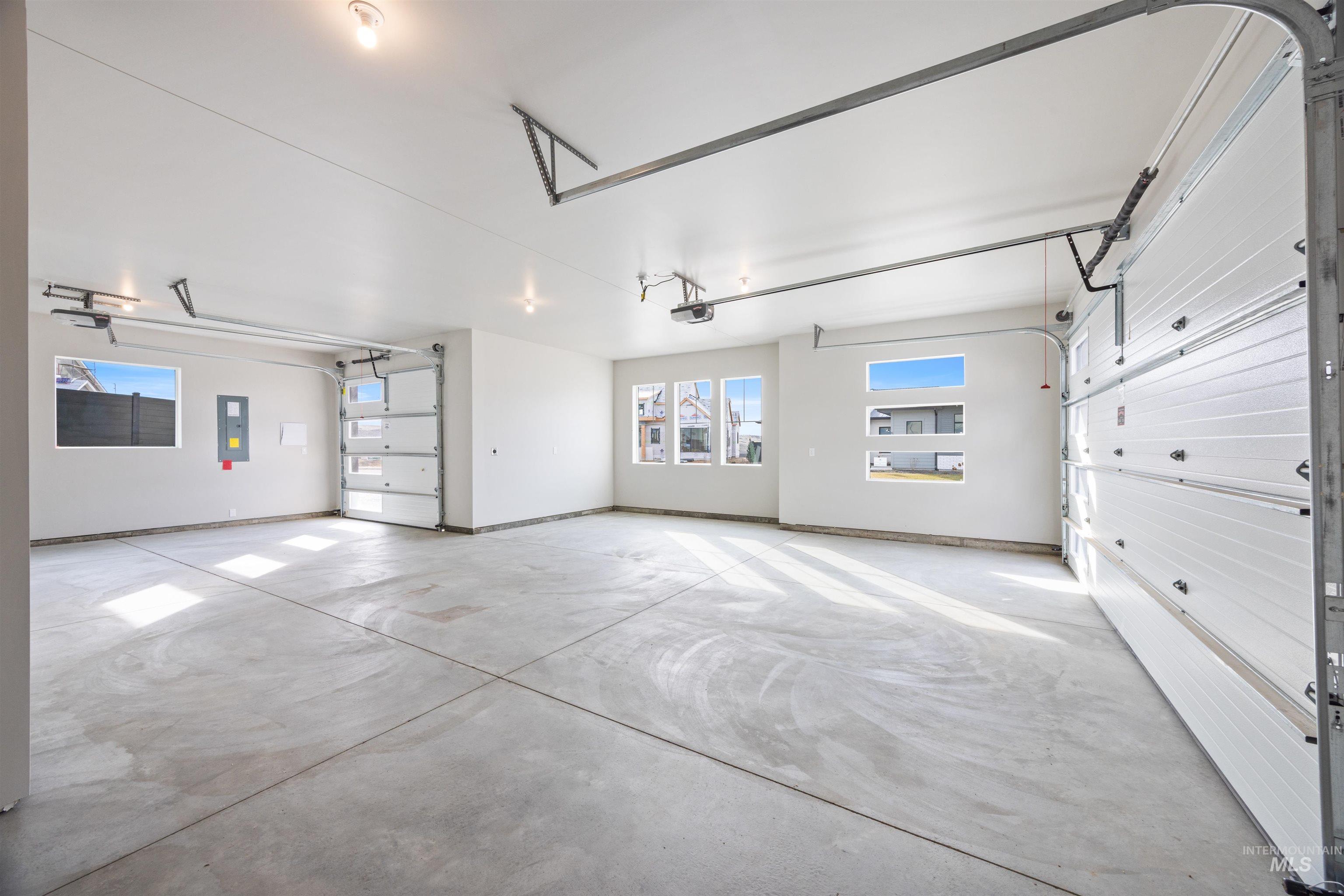 Garage with electric panel and baseboards