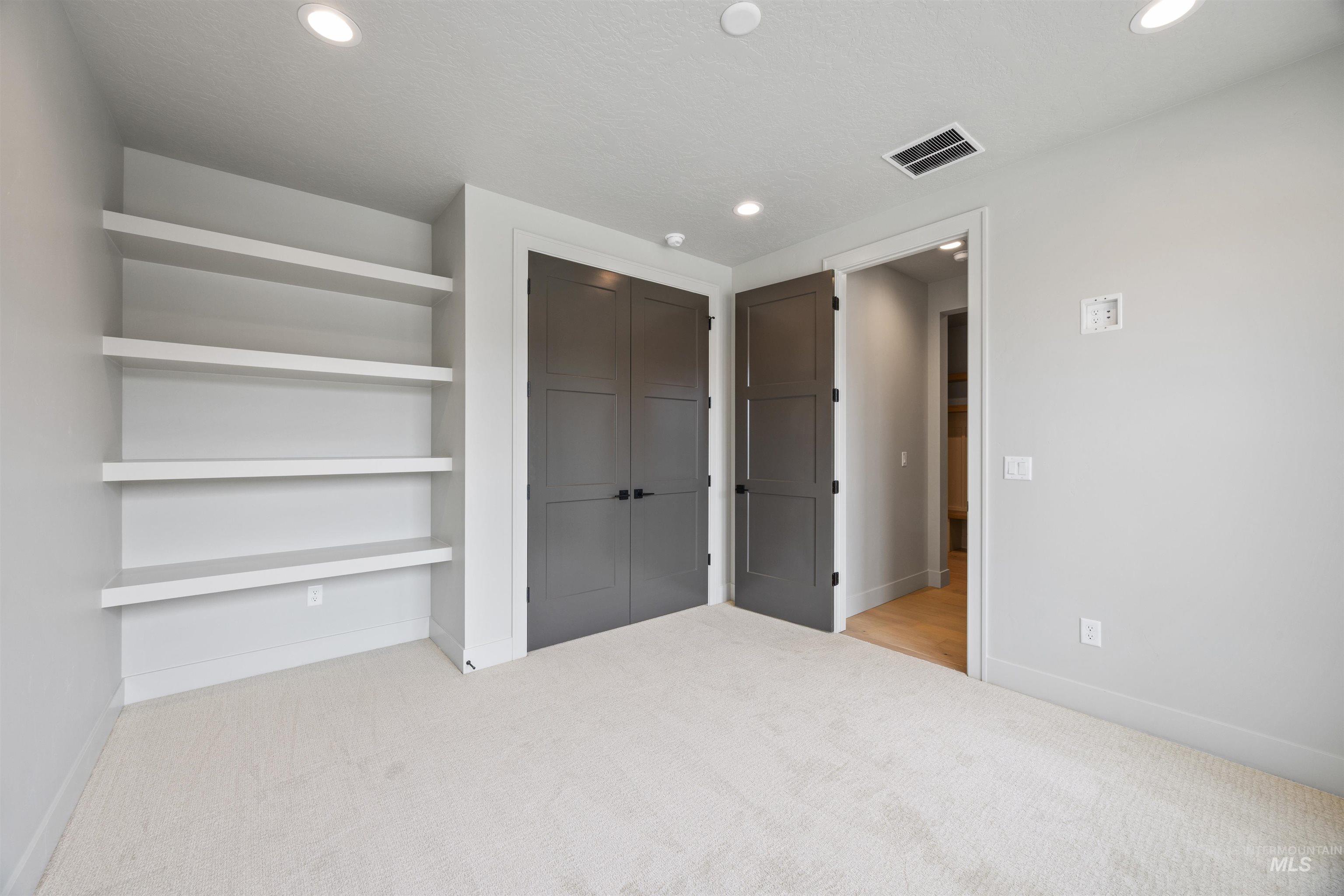 Unfurnished bedroom featuring light colored carpet, a closet, and recessed lighting