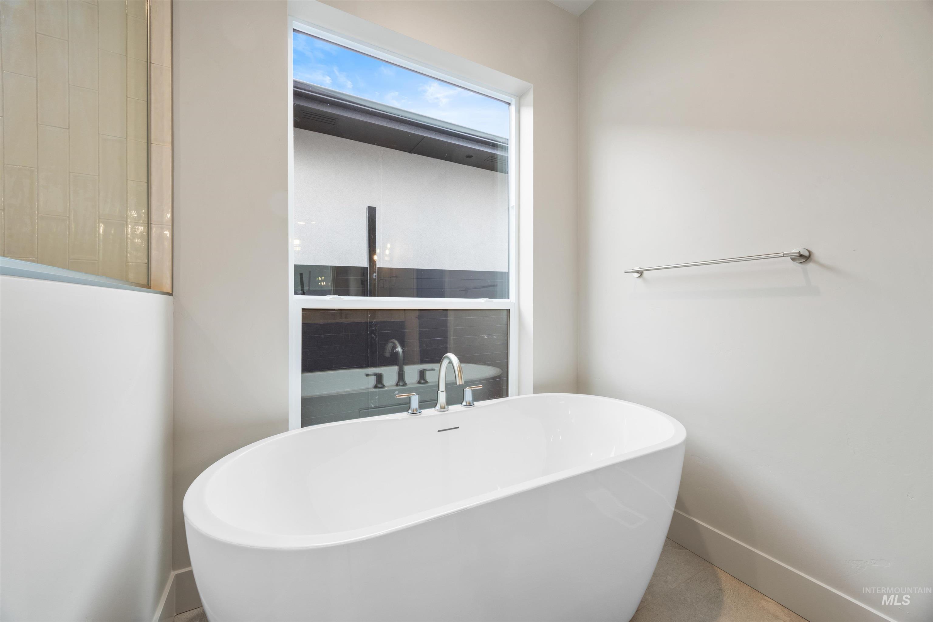 Bathroom featuring a freestanding tub and baseboards