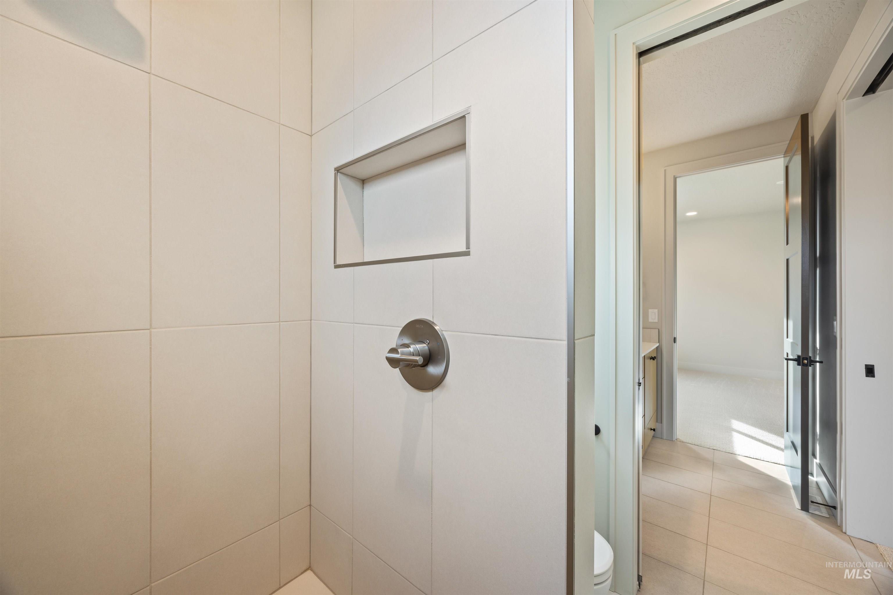 Bathroom with a tile shower and light tile patterned floors