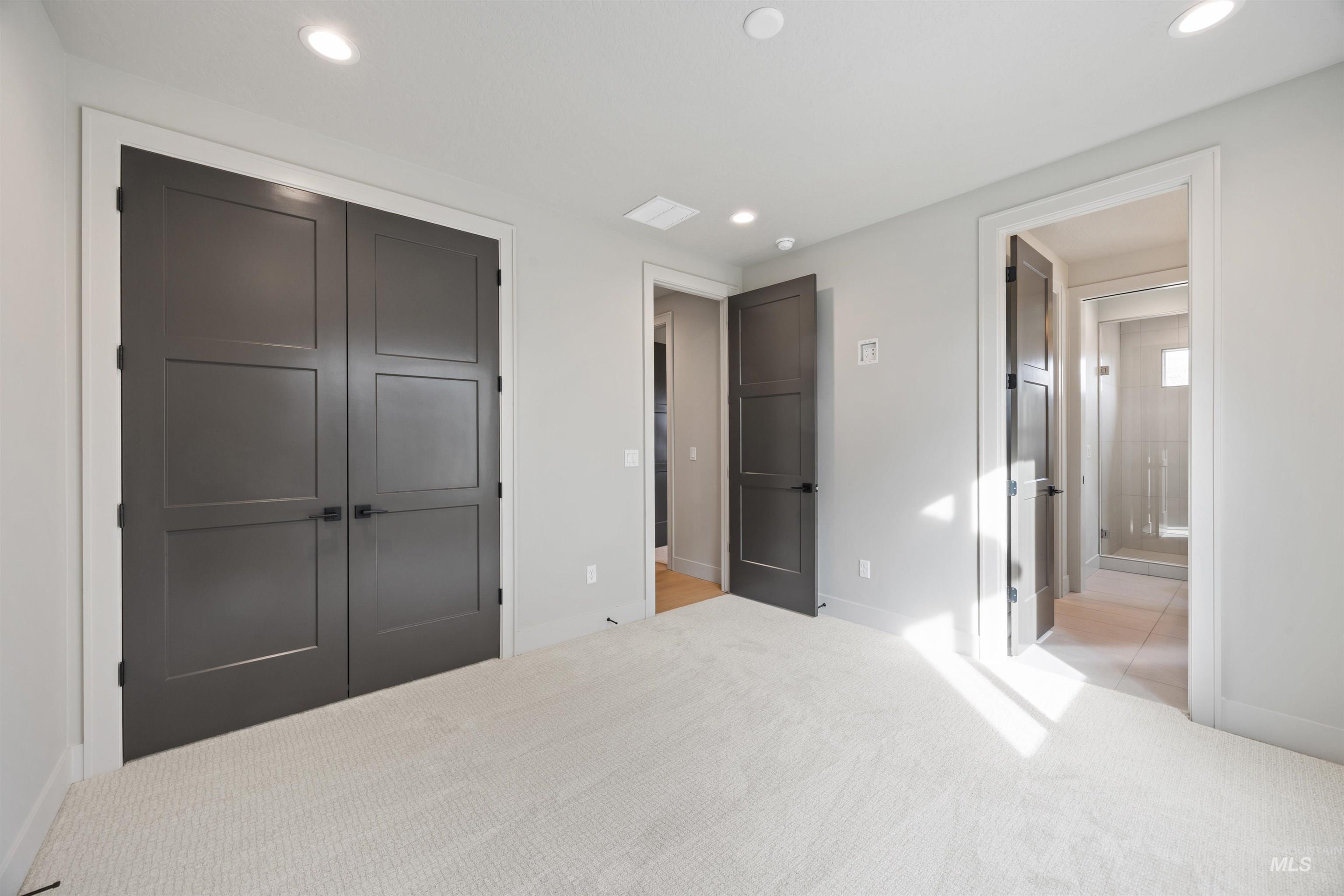 Unfurnished bedroom featuring carpet floors, a closet, connected bathroom, and recessed lighting