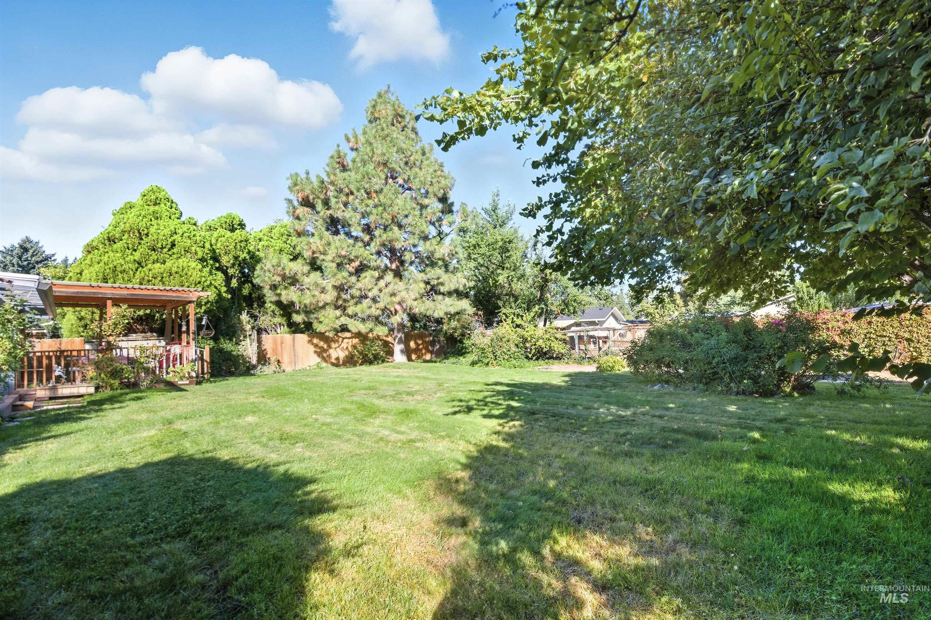 View of grassy yard with a deck