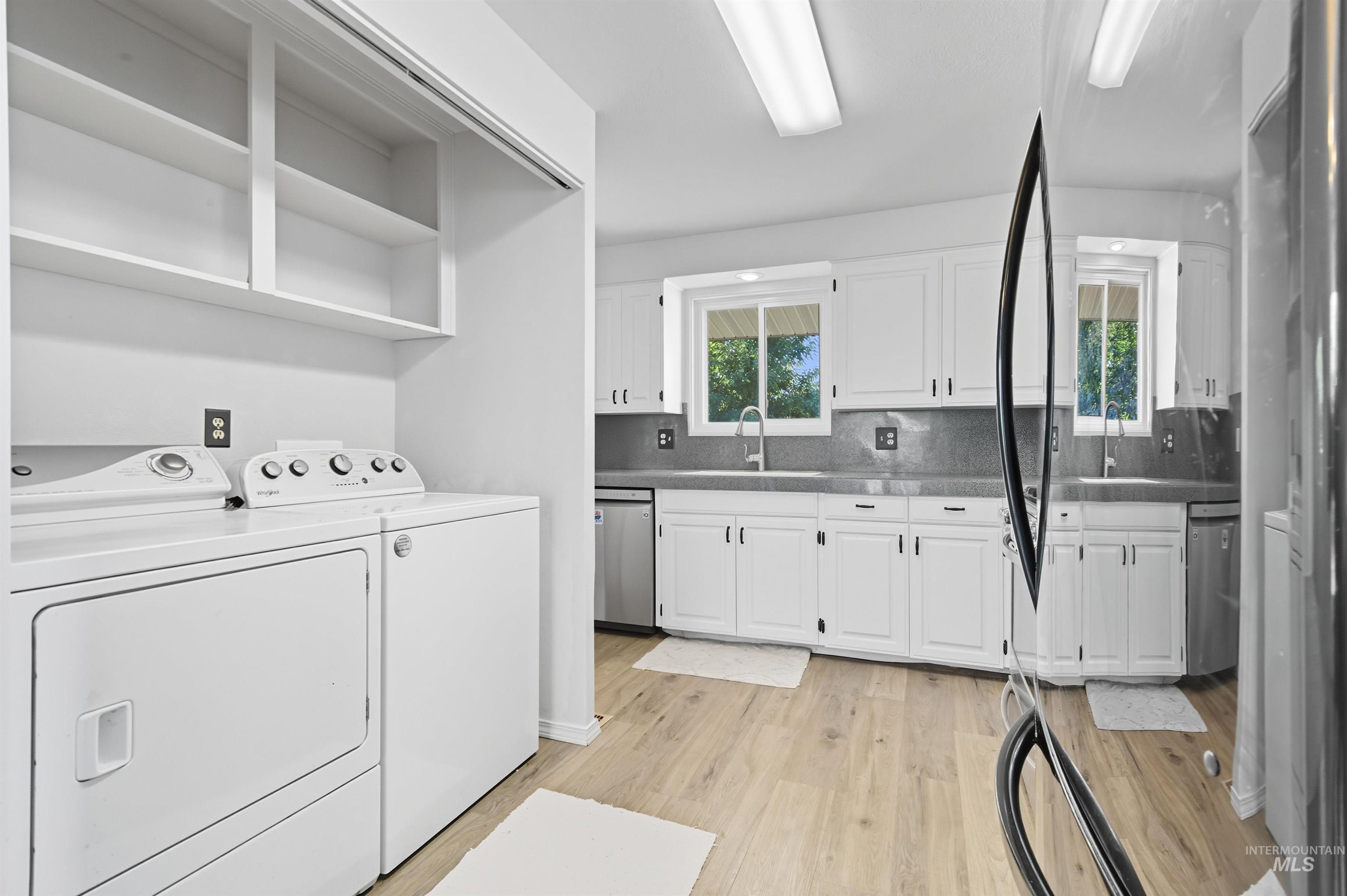 Laundry area featuring light wood-style floors and washer and clothes dryer