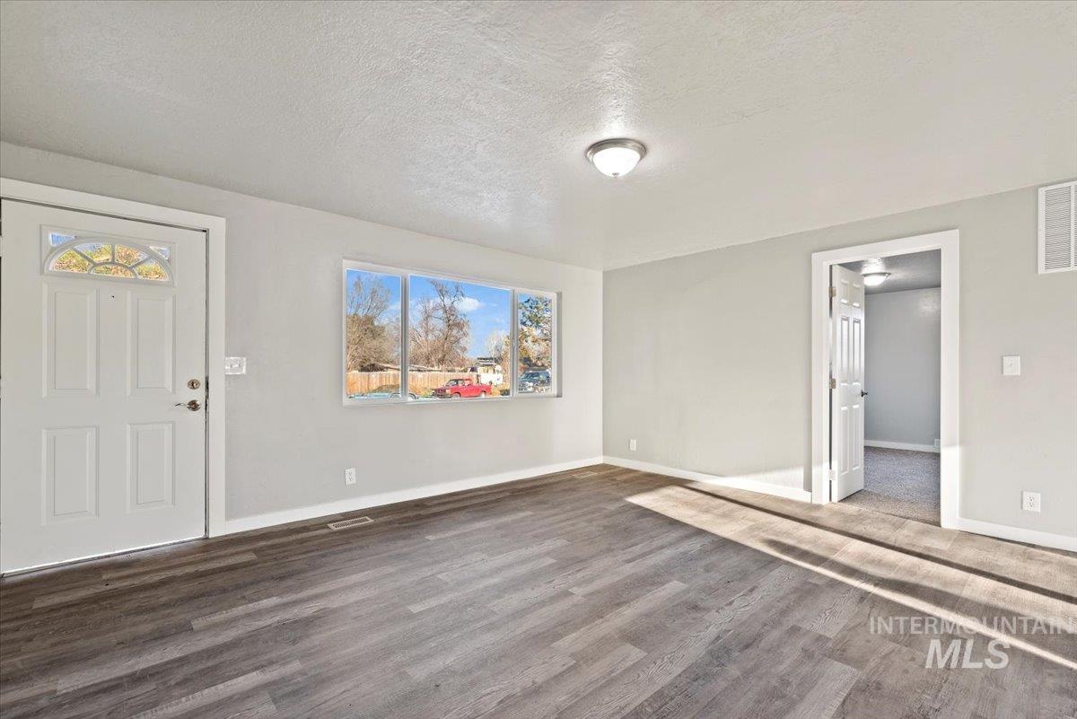 Entryway featuring a textured ceiling and dark wood-type flooring