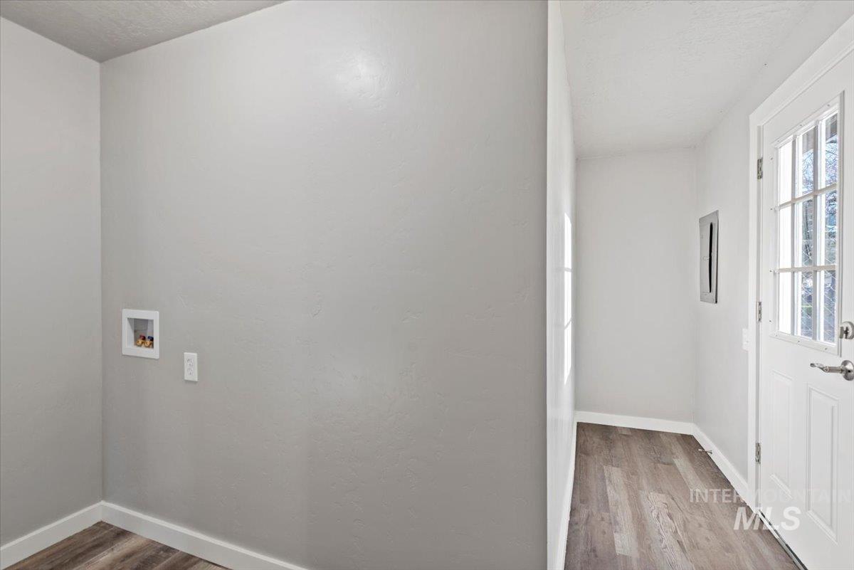 Washroom with light wood finished floors, hookup for a washing machine, and a textured ceiling