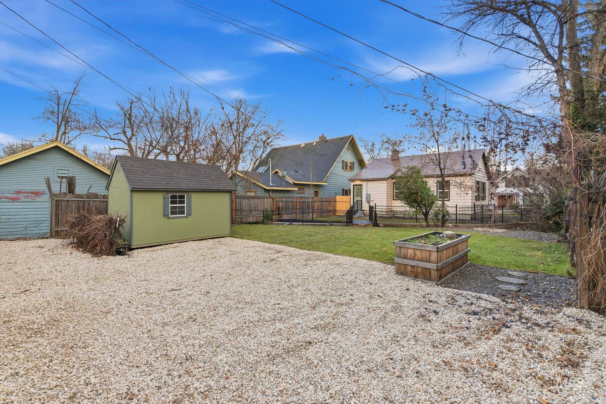 Fenced backyard with a vegetable garden and a shed