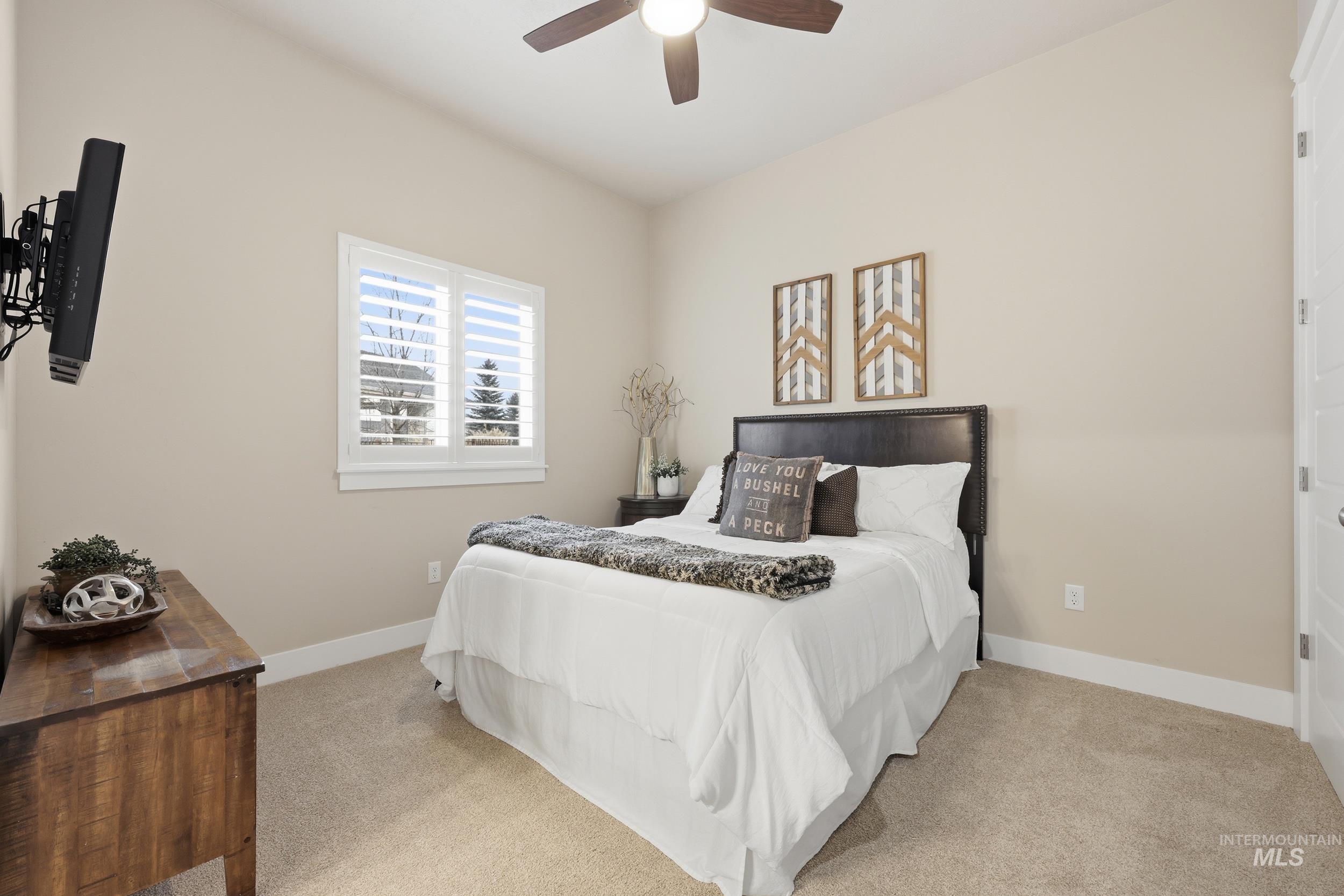 Carpeted bedroom with baseboards and a ceiling fan