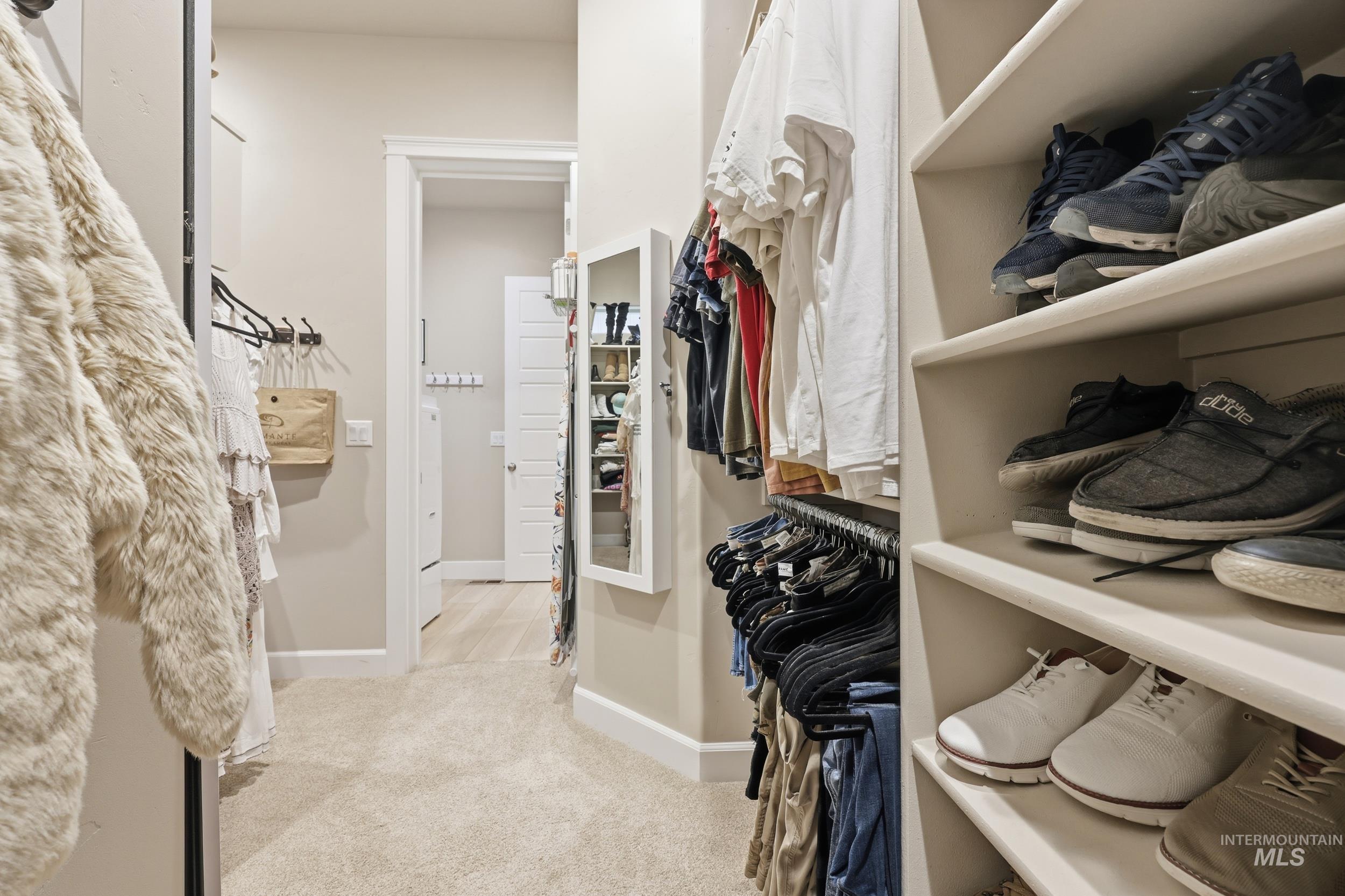 Walk in closet with light colored carpet