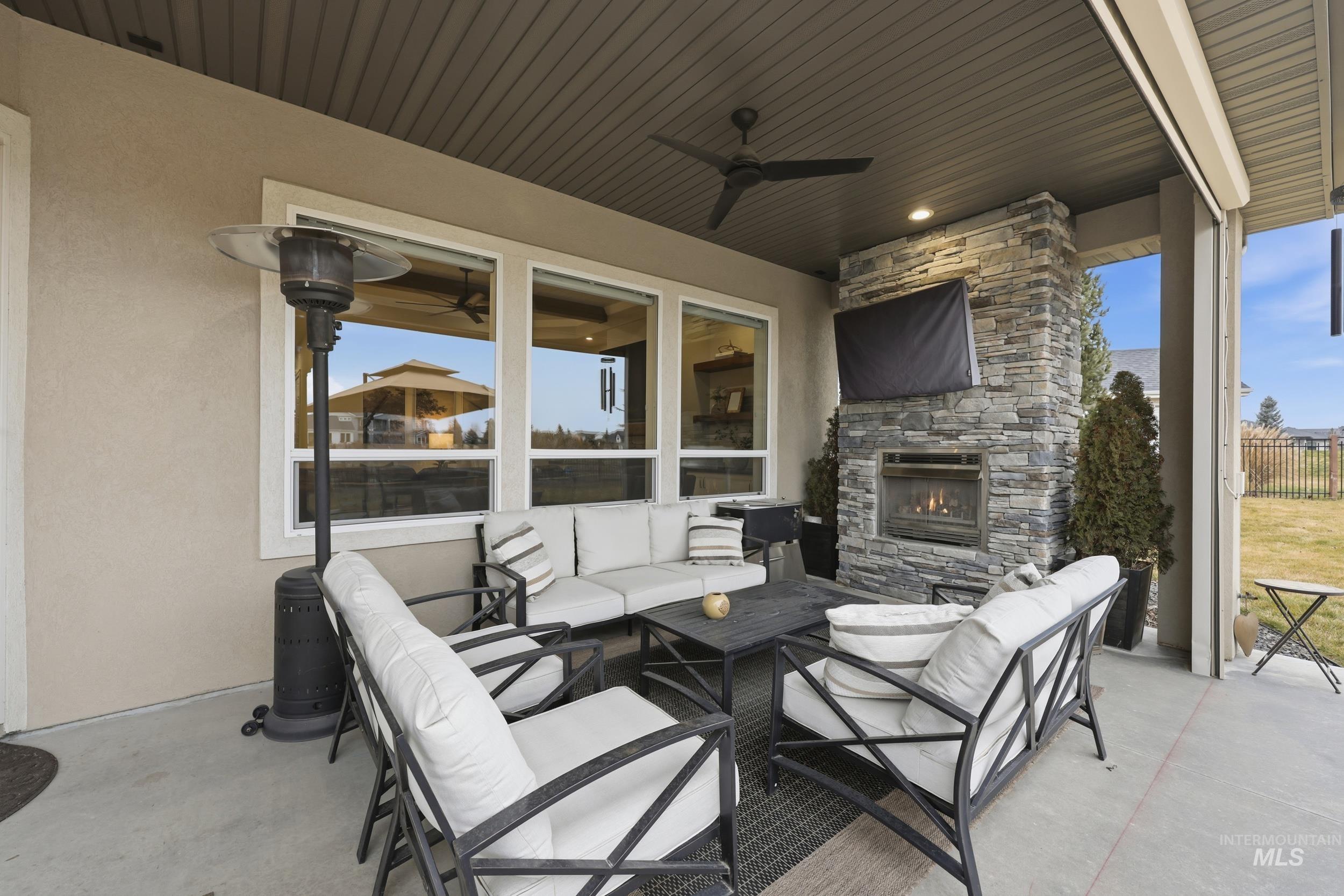 View of patio / terrace featuring an outdoor living space with a fireplace and ceiling fan