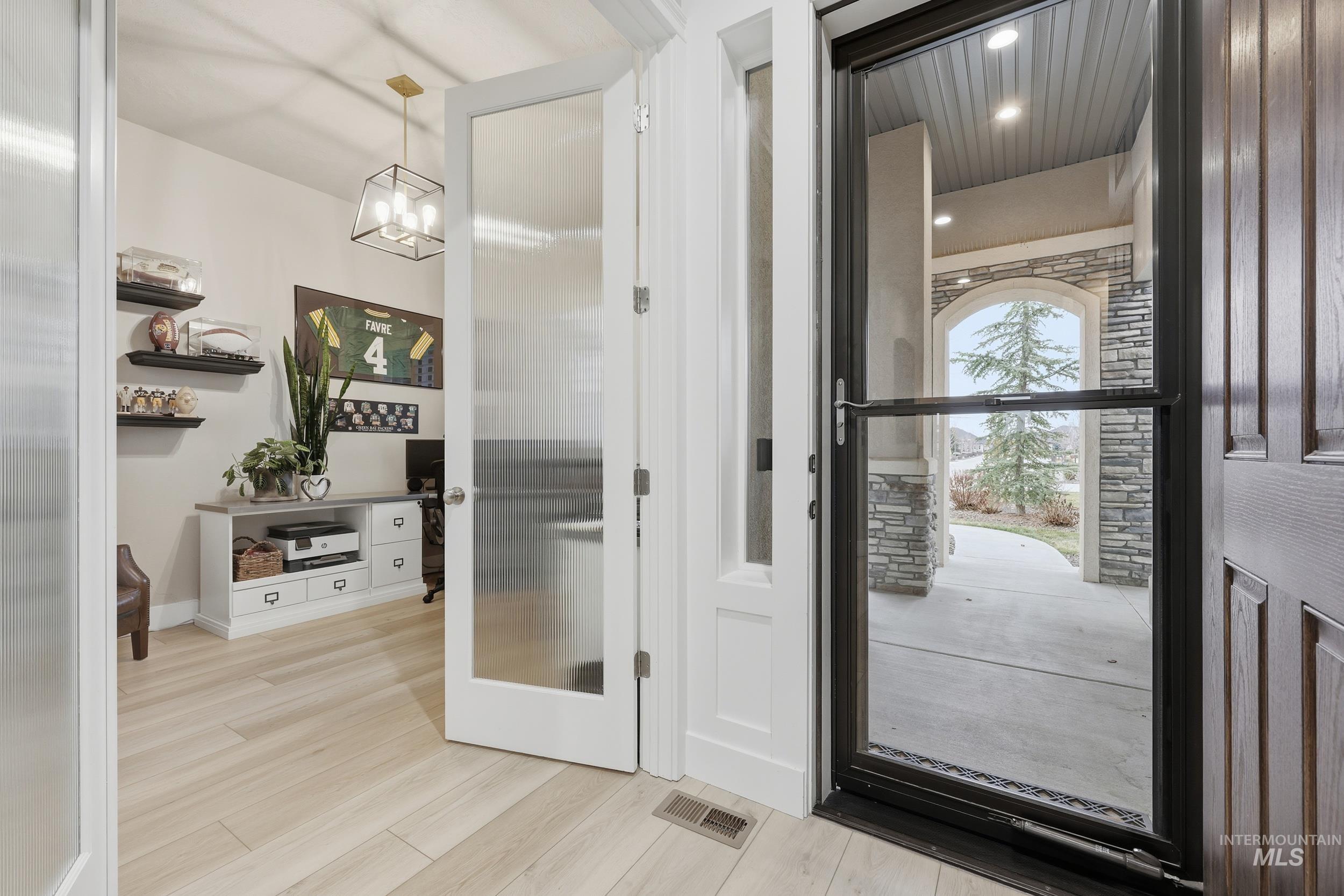 Foyer entrance with light wood-style floors and recessed lighting