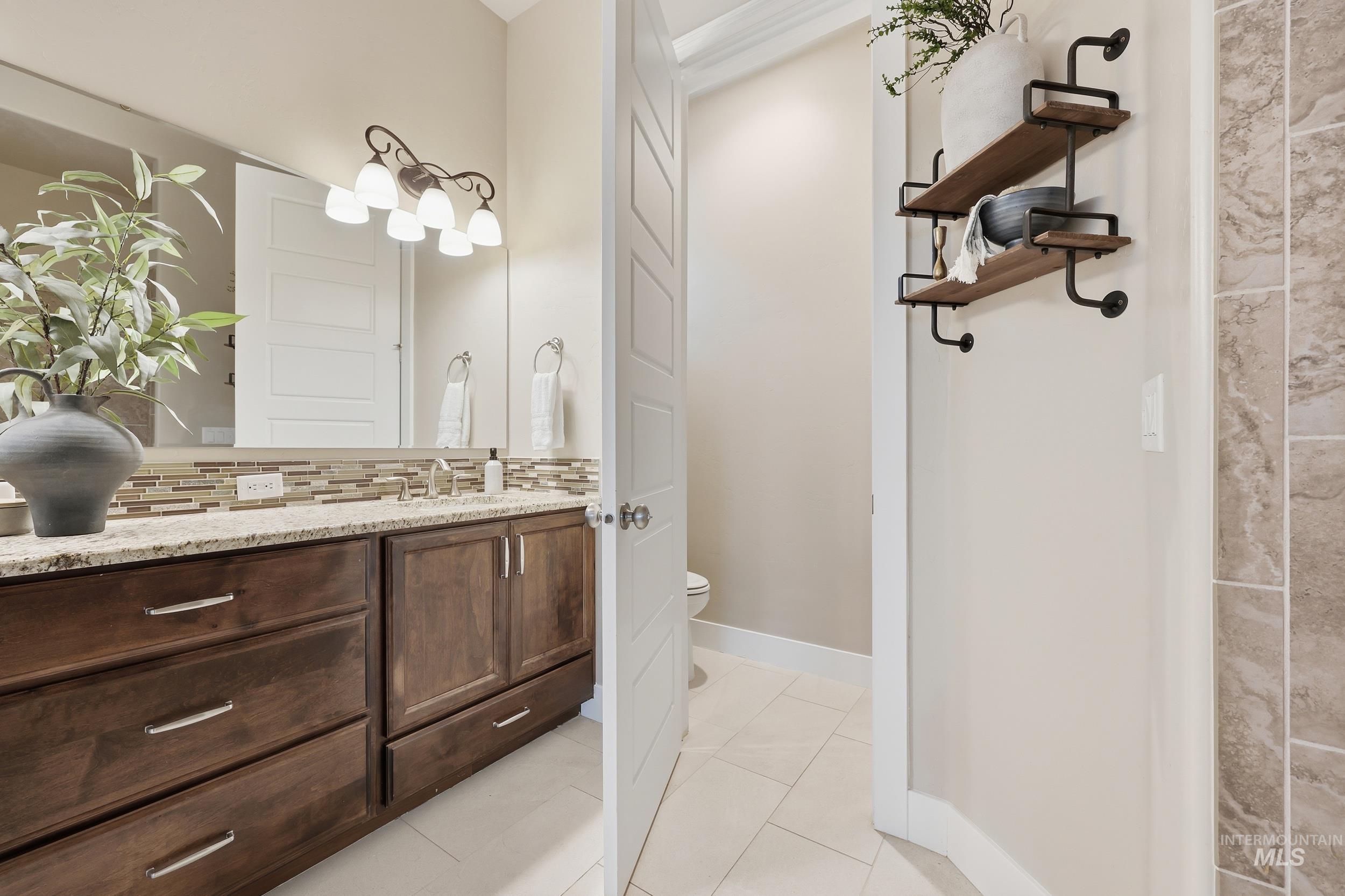 Bathroom with vanity, light tile patterned floors, and decorative backsplash