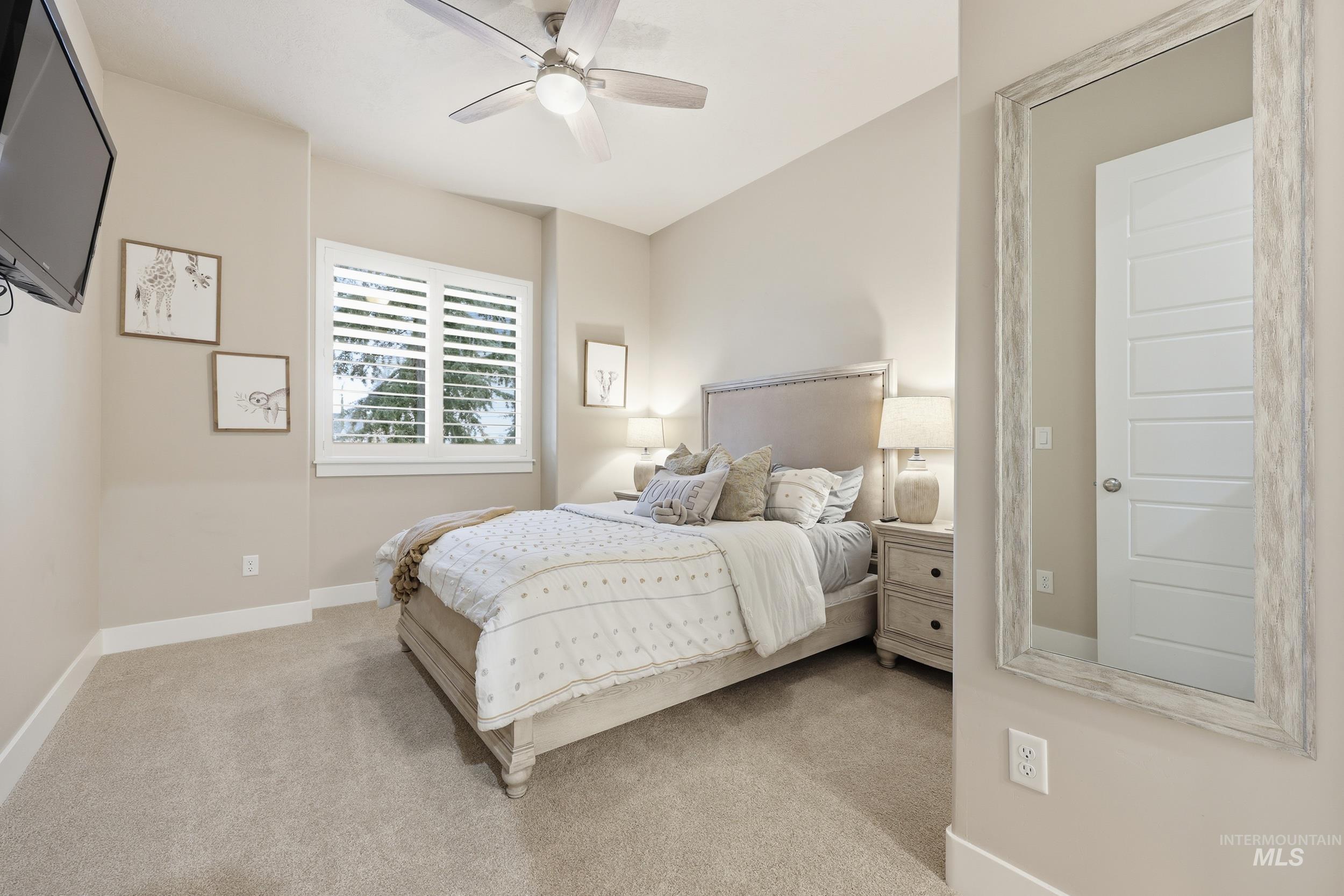 Bedroom with light colored carpet and ceiling fan