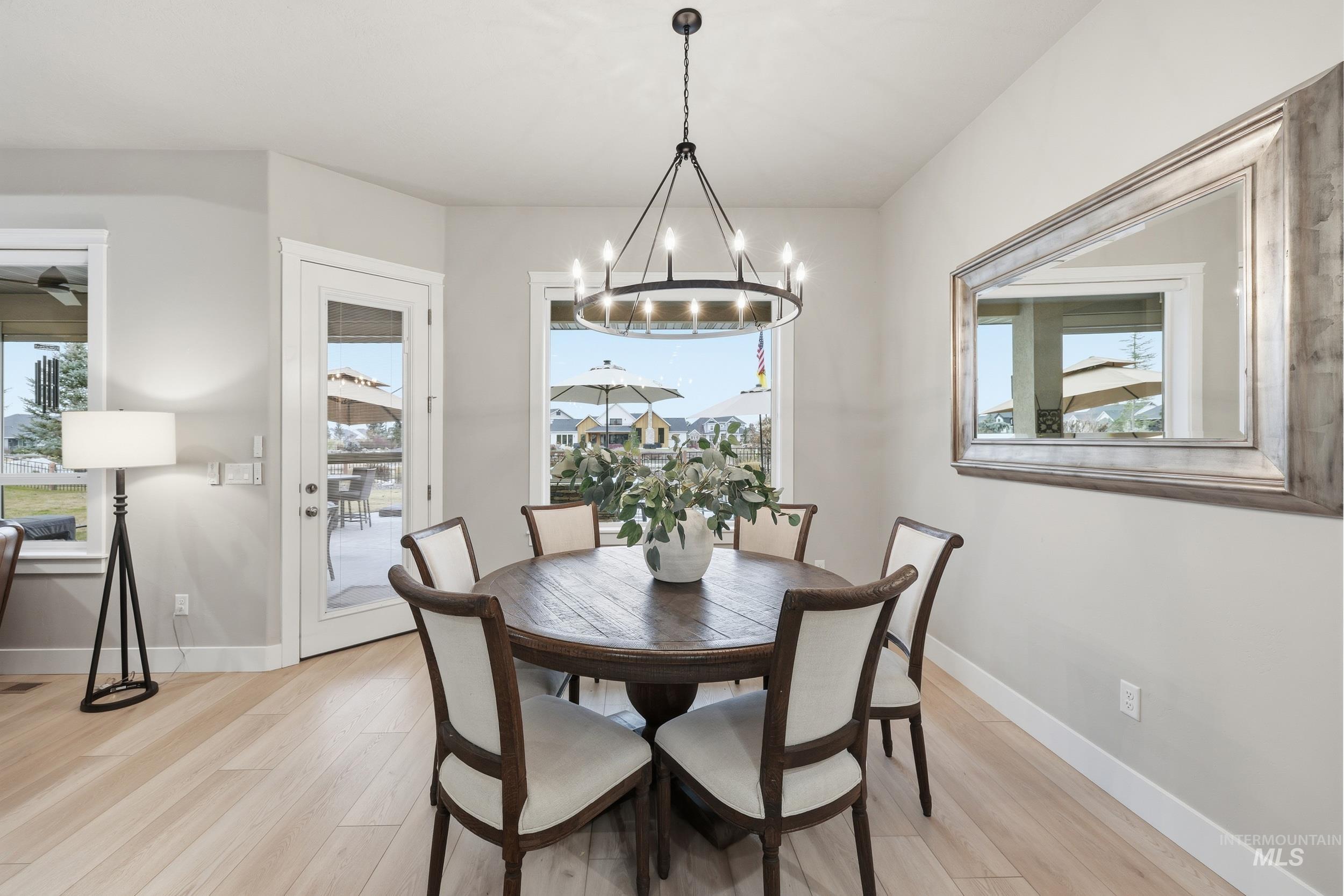 Dining area featuring light wood finished floors, healthy amount of natural light, and a chandelier