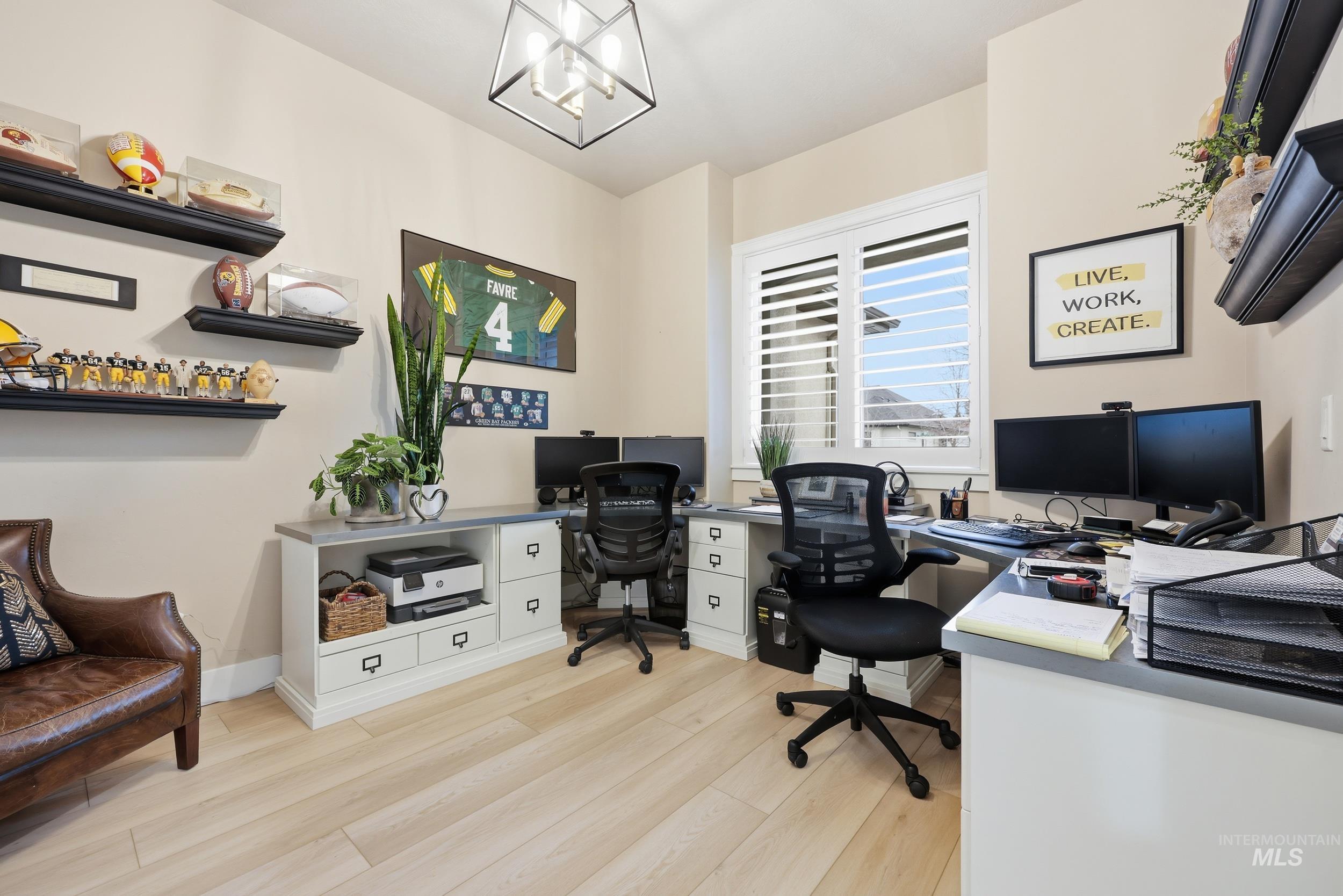Office space with light wood-type flooring and a chandelier