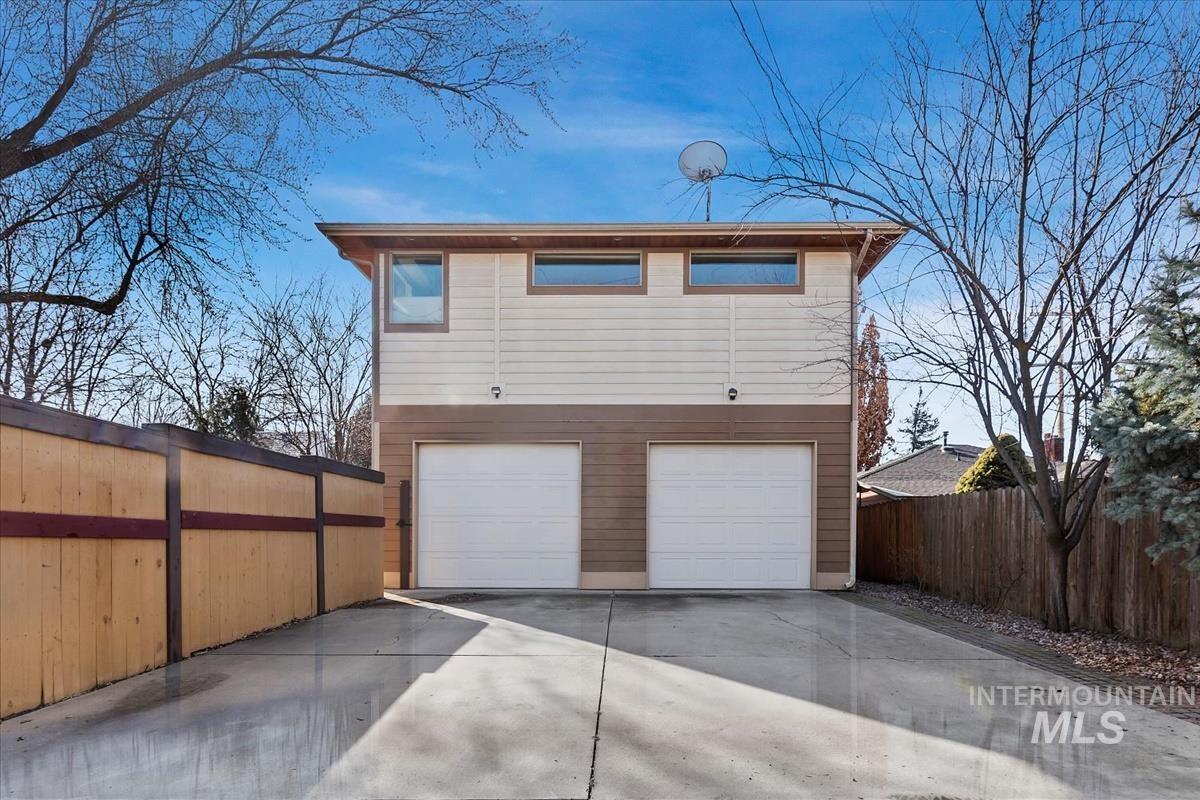 View of front of house with concrete driveway and a garage