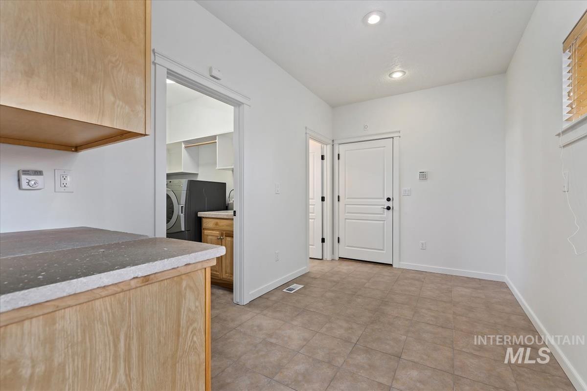 Kitchen featuring washer / clothes dryer, recessed lighting, and light tile patterned floors