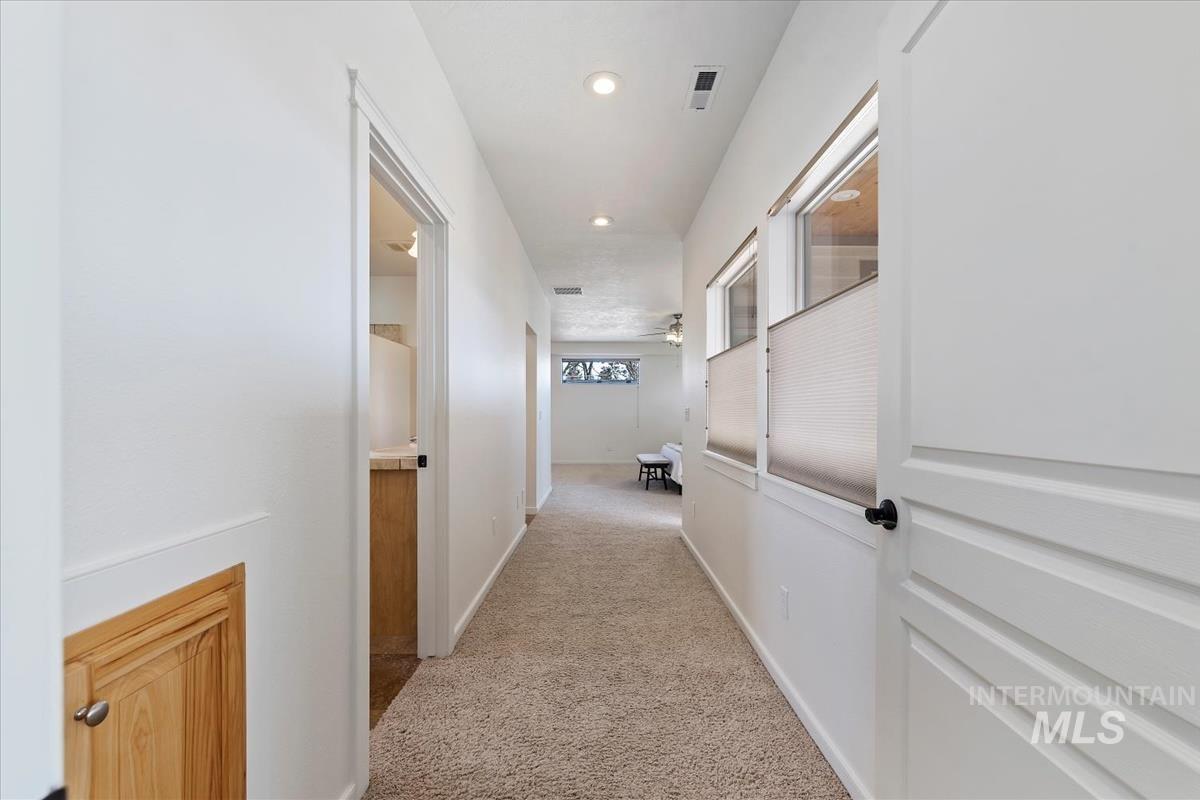 Corridor featuring light colored carpet and recessed lighting