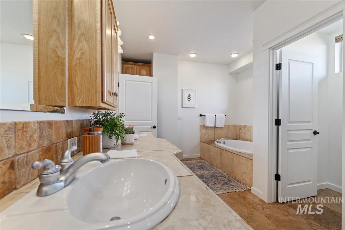 Full bath featuring a bath, recessed lighting, and double vanity