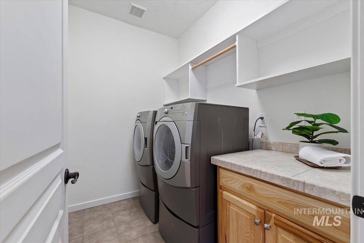 Laundry room with separate washer and dryer and cabinet space