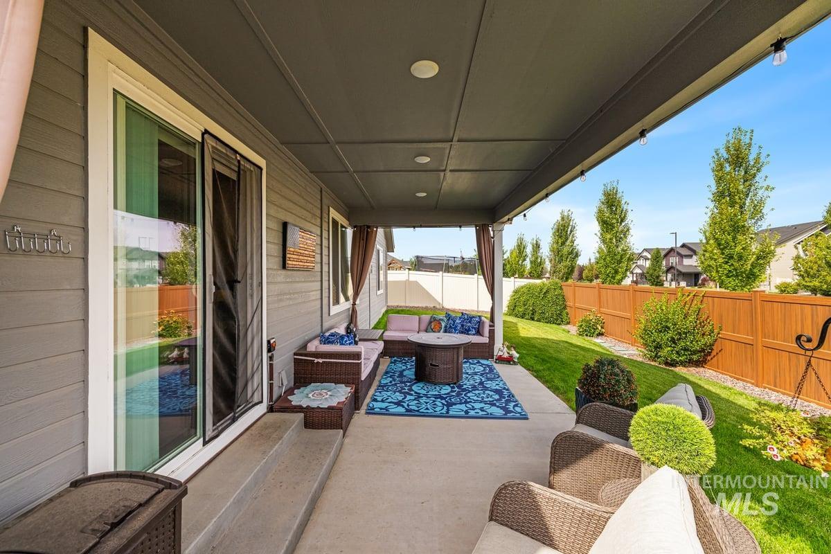 Fenced backyard with an outdoor living space and a patio area