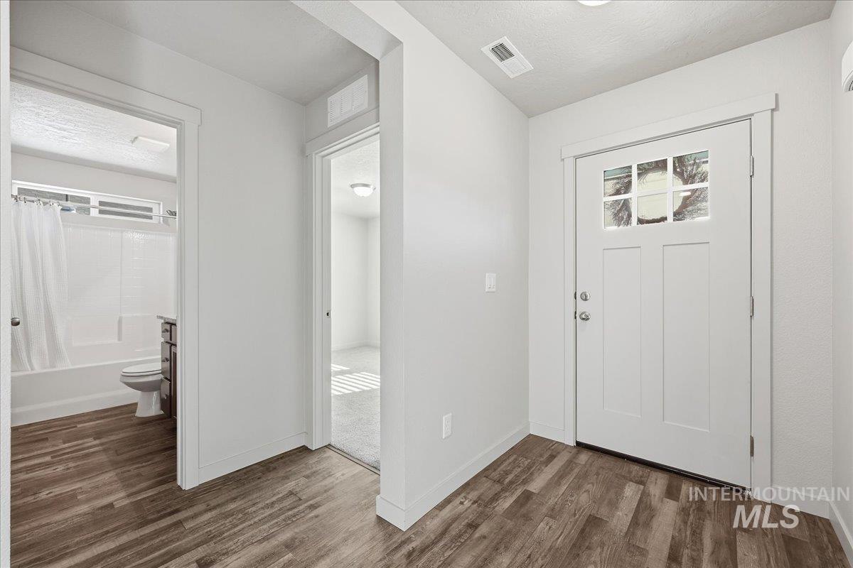 Foyer featuring a textured ceiling and dark wood finished floors